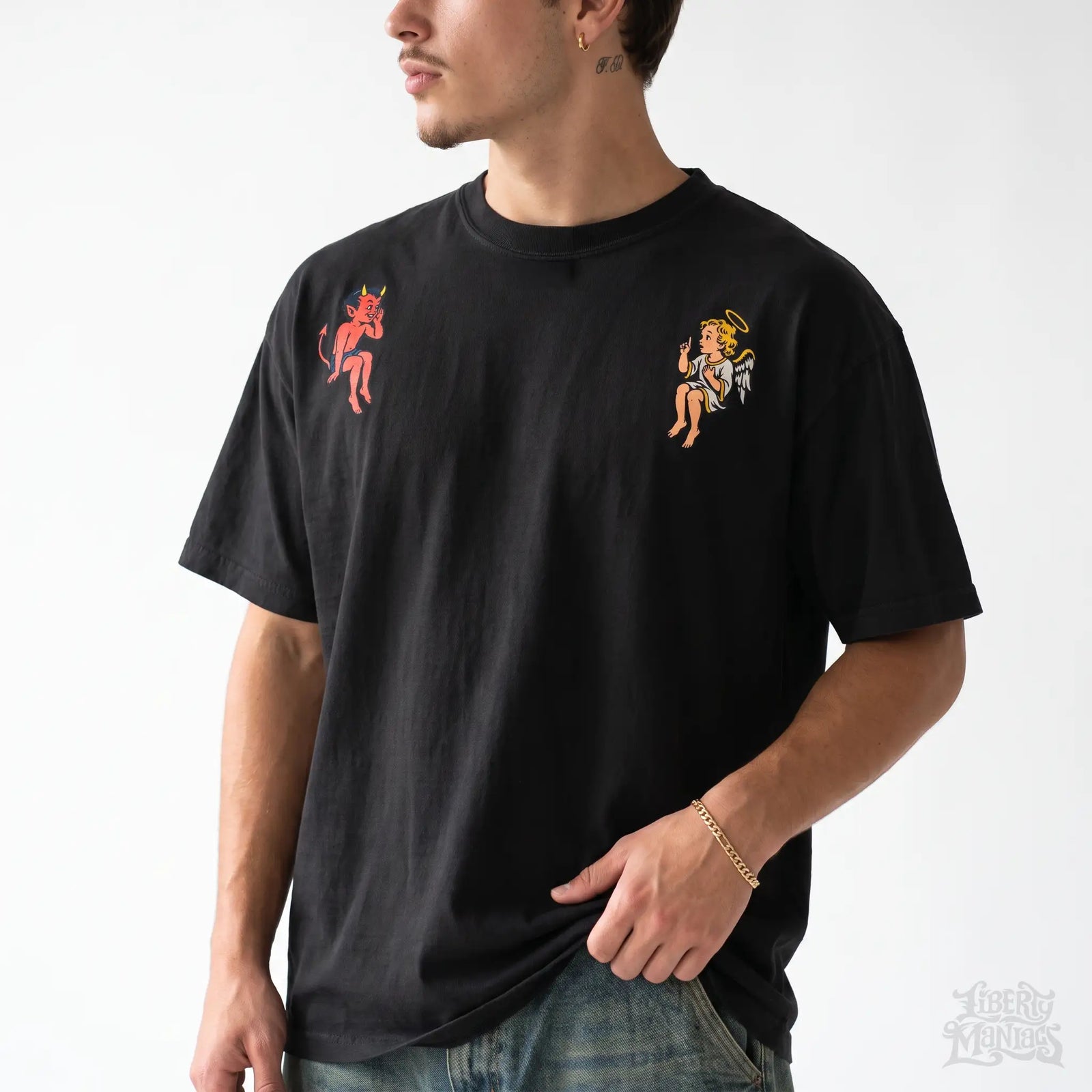 Male model wearing the black angel and devil shoulder graphic tee in a white studio