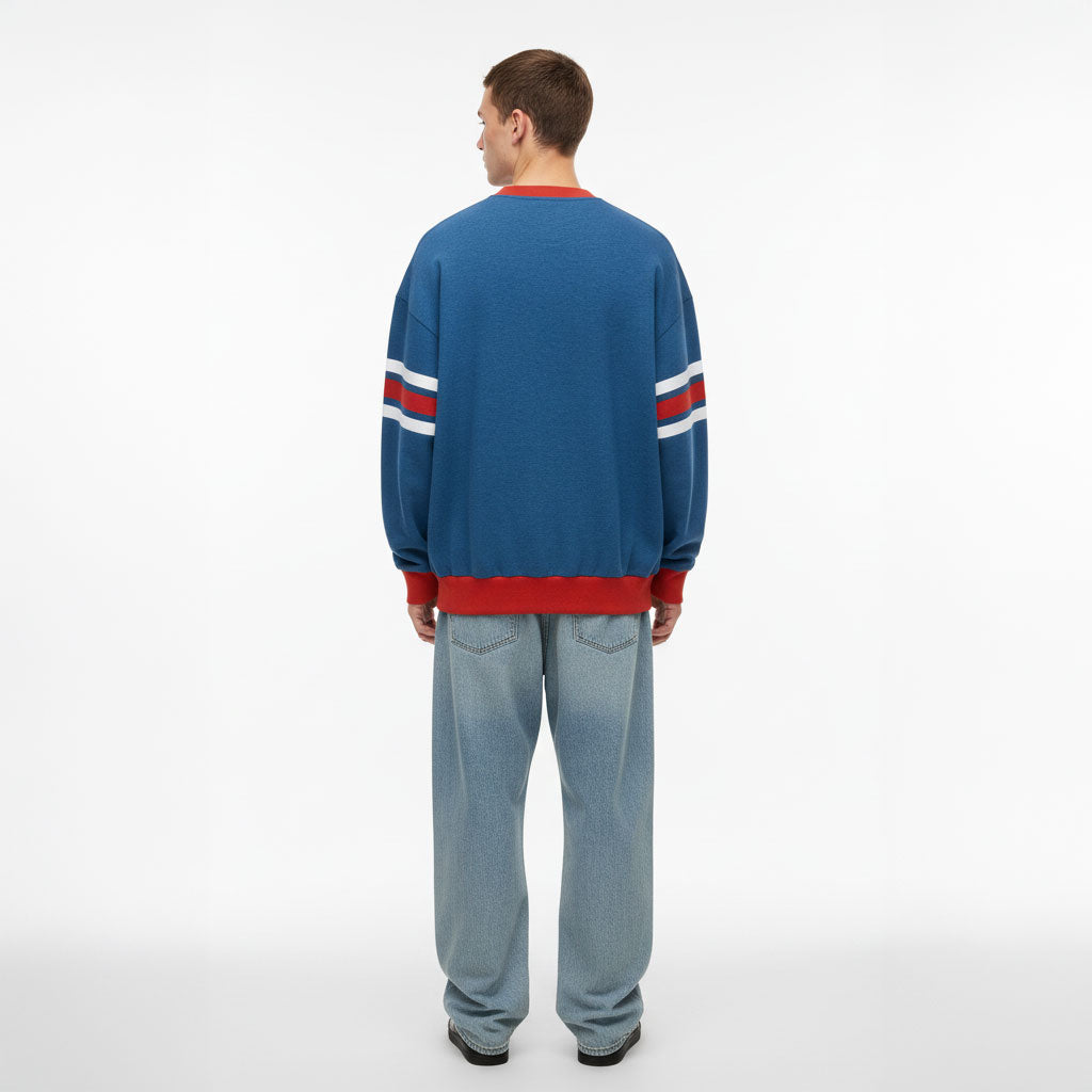 Person wearing a blue sweater with red and white stripes on a white background