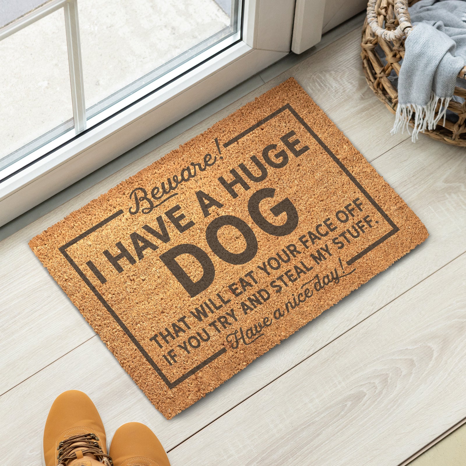 Doormat with humorous text on a wooden floor next to a glass door.