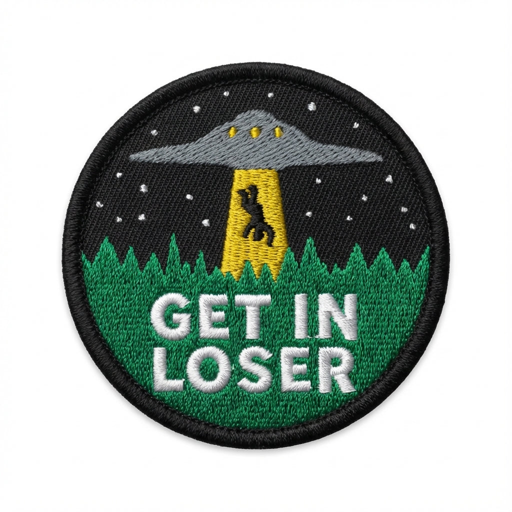 A round embroidered morale patch that says 'et in loser' and shows a man being beamed into a UFO.
