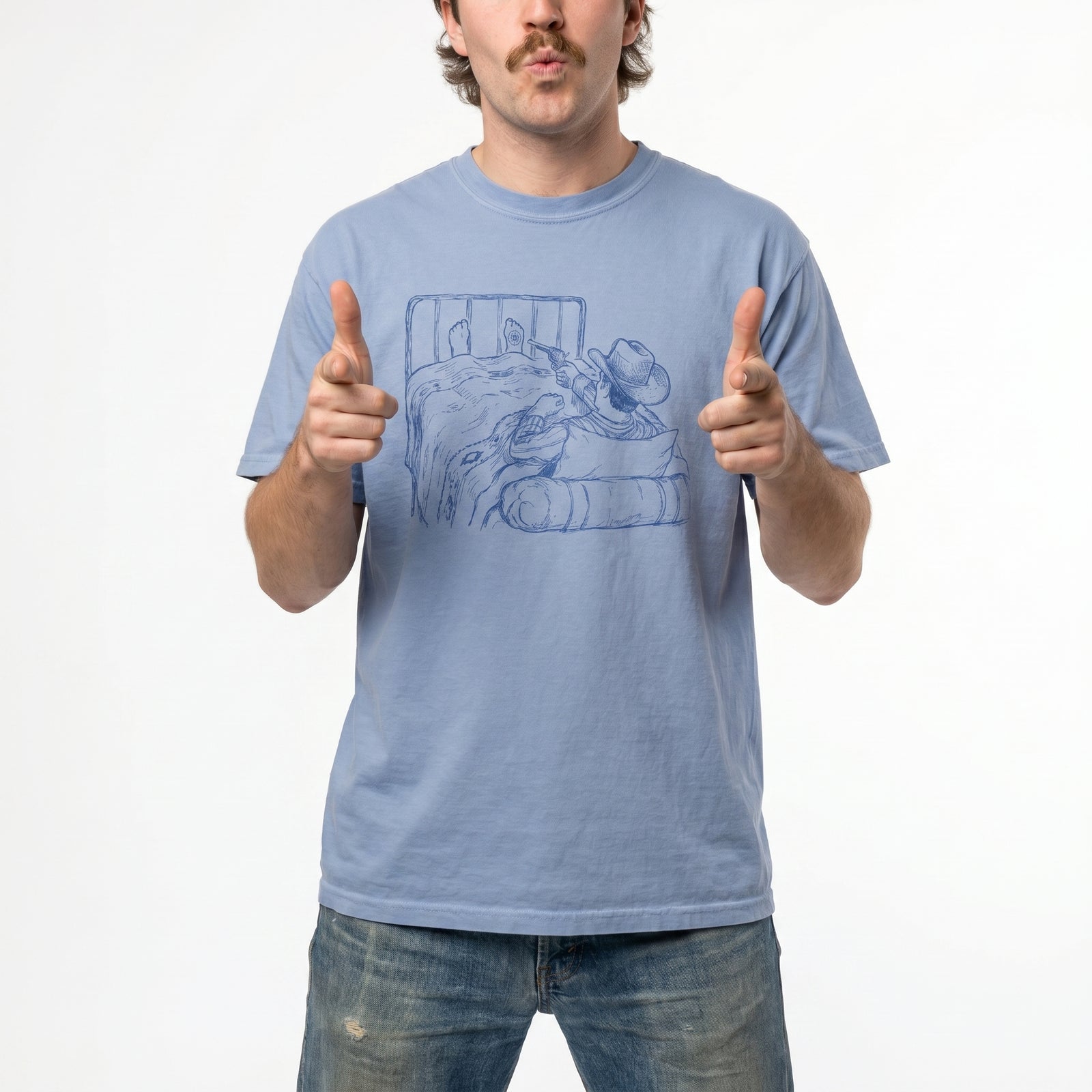 Man wearing a light blue t-shirt with a graphic of a cowboy in bed shooting himself in the foot on a white background
