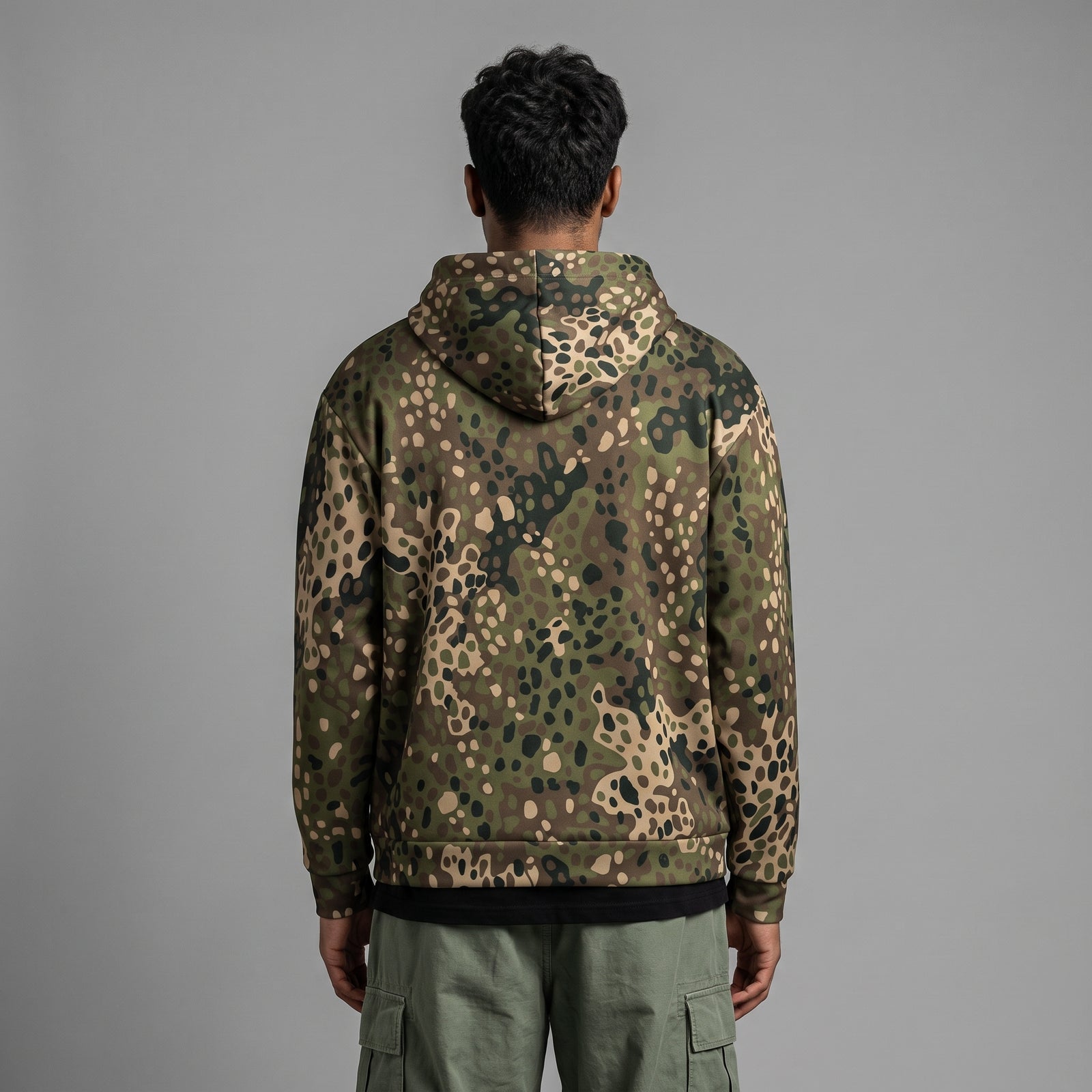 Man wearing the Erbsenmuster Pea Dot Field Green camo zip hoodie, back view