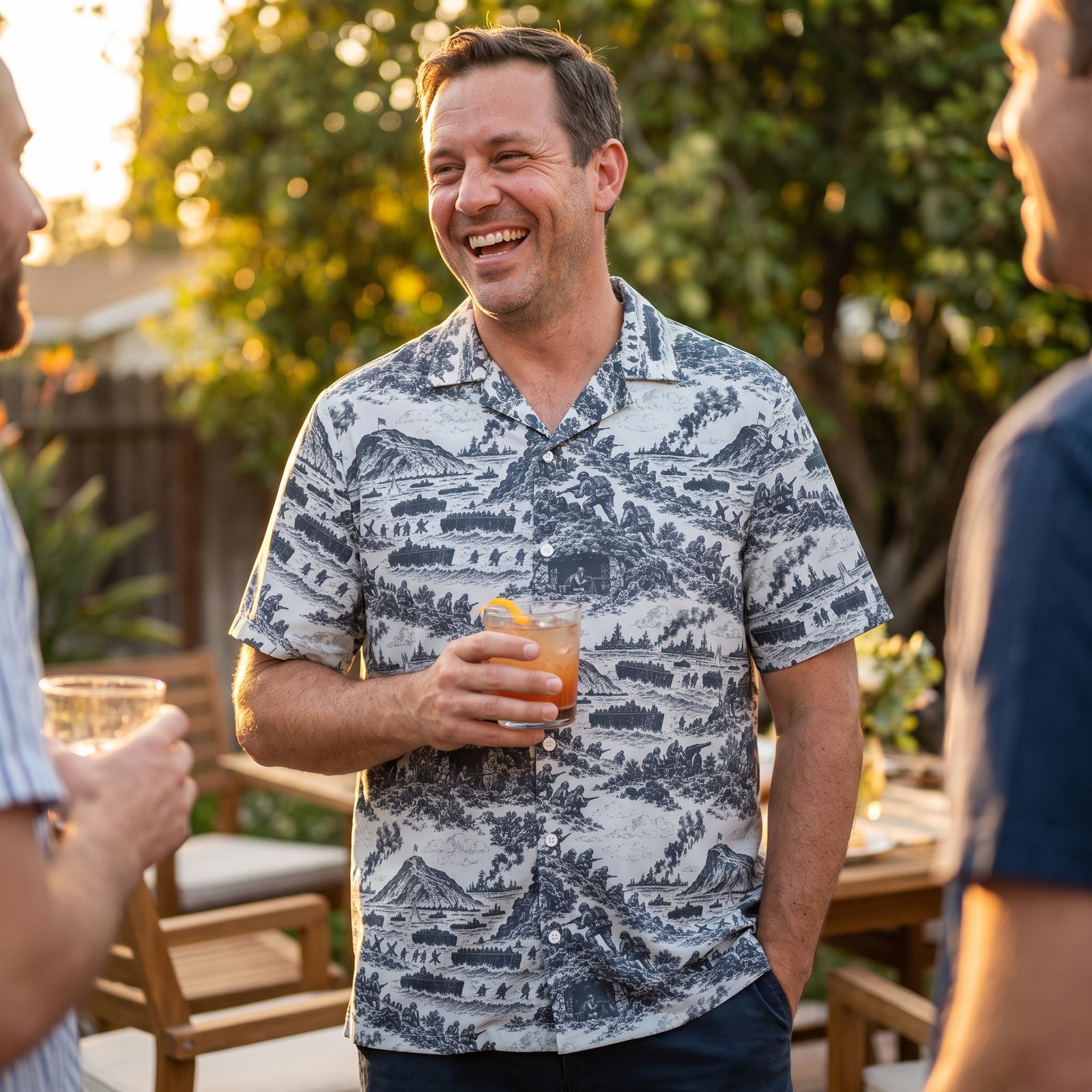 Man speaks with friends wearing a Iwo Jima Print Button-Up Relaxed Fit Shirt by Liberty Maniacs at a BBQ.