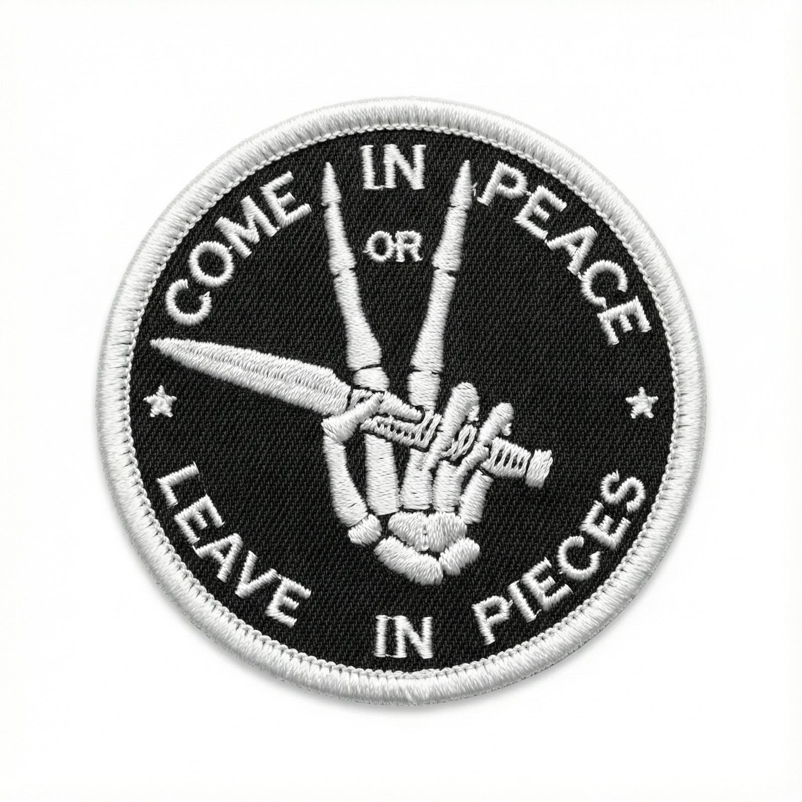 Patch with a hand holding scissors and text 'Come in peace or leave in pieces' on a black background.