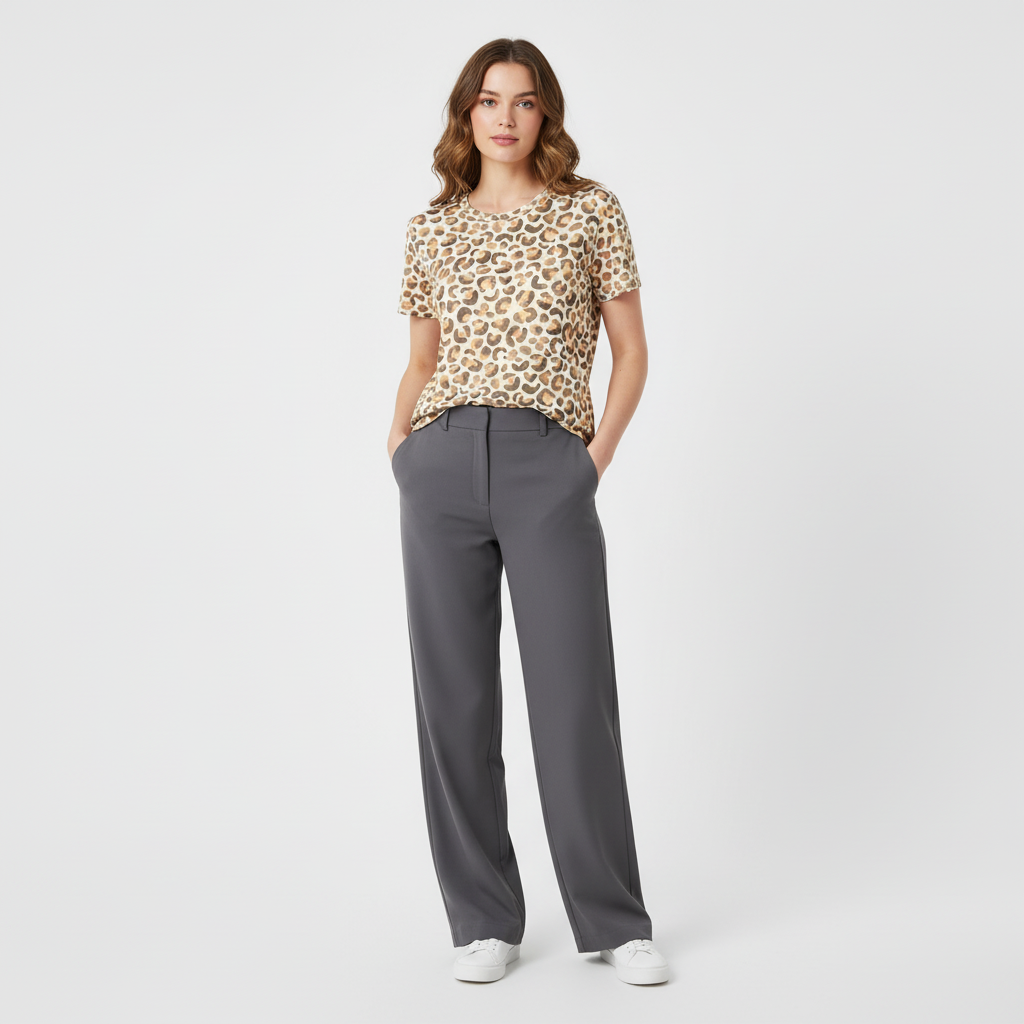 Woman wearing a leopard print top and gray pants on a white background