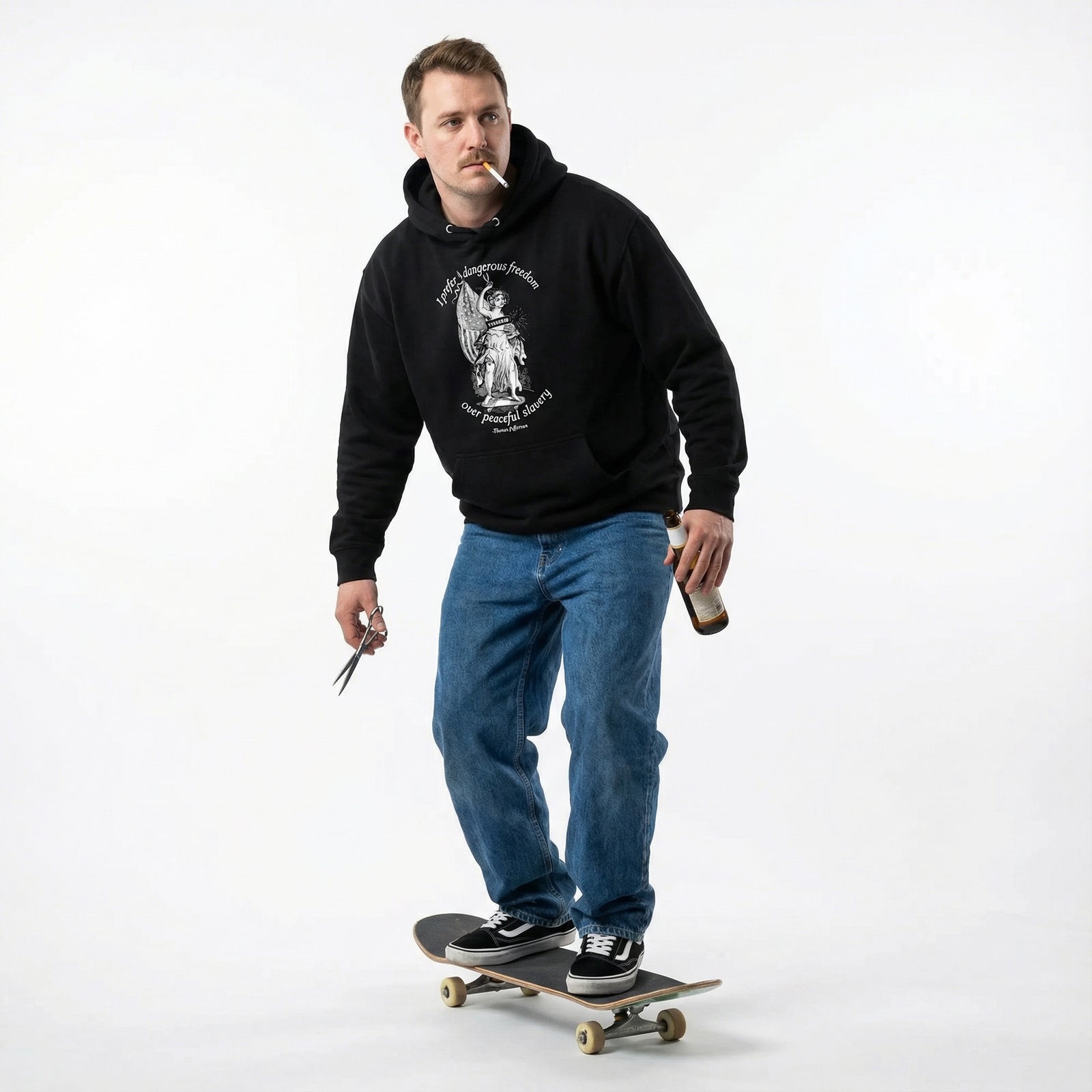 Man wearing a black hoodie and blue jeans, standing on a skateboard with a white background