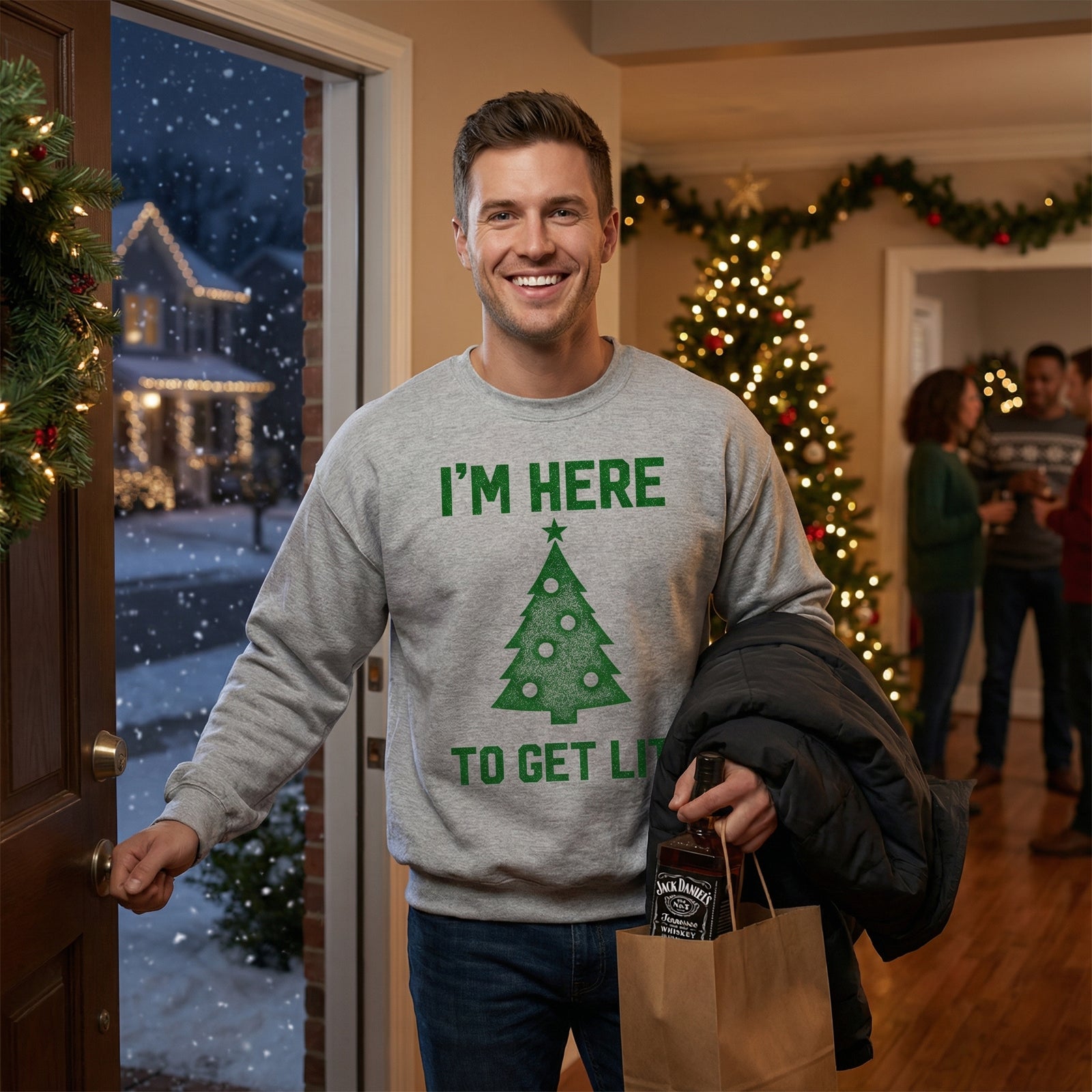 Man wearing a sweater with a Christmas tree design and text, standing in a festively decorated room.