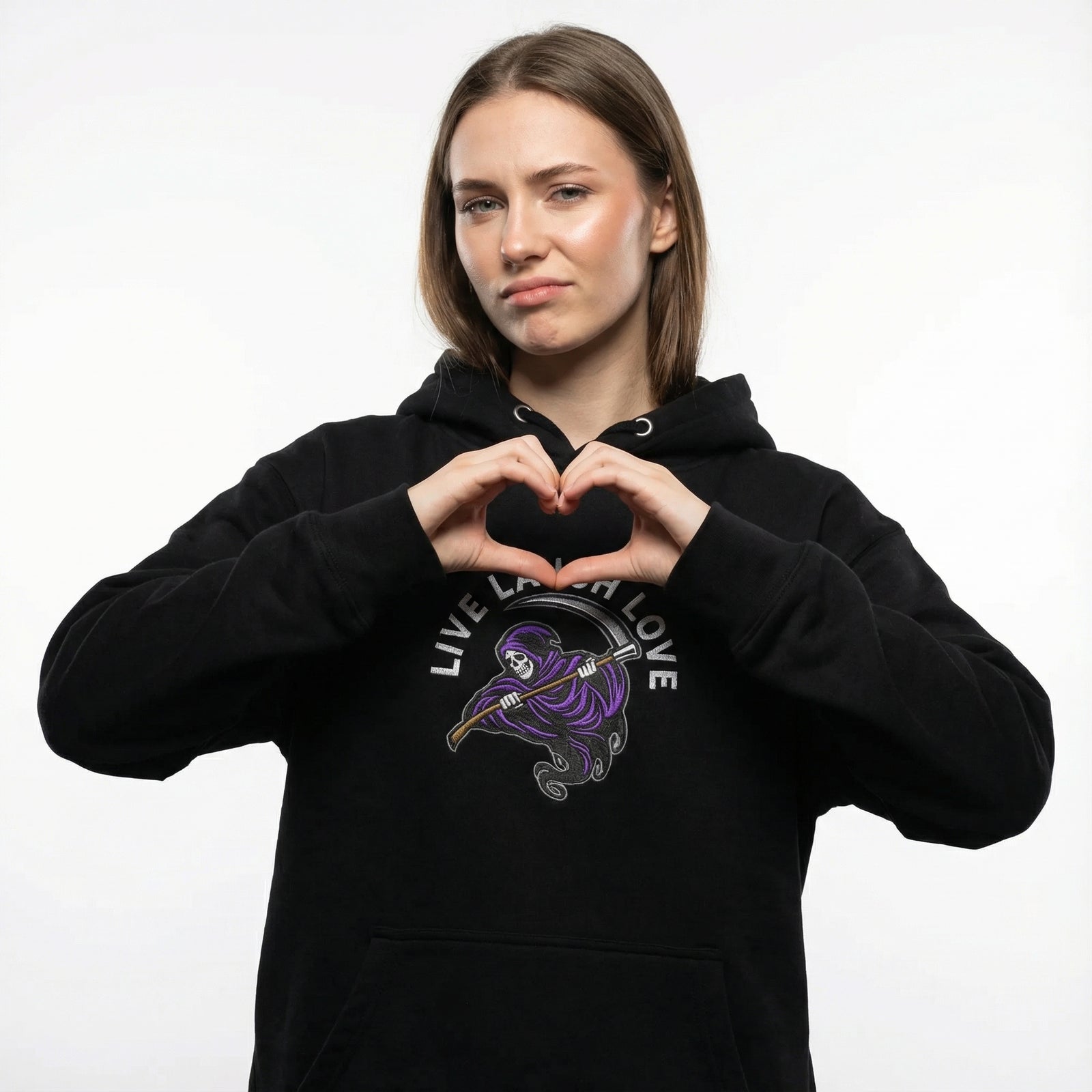 Person wearing a black hoodie with a graphic design and text, making a heart shape with their hands.
