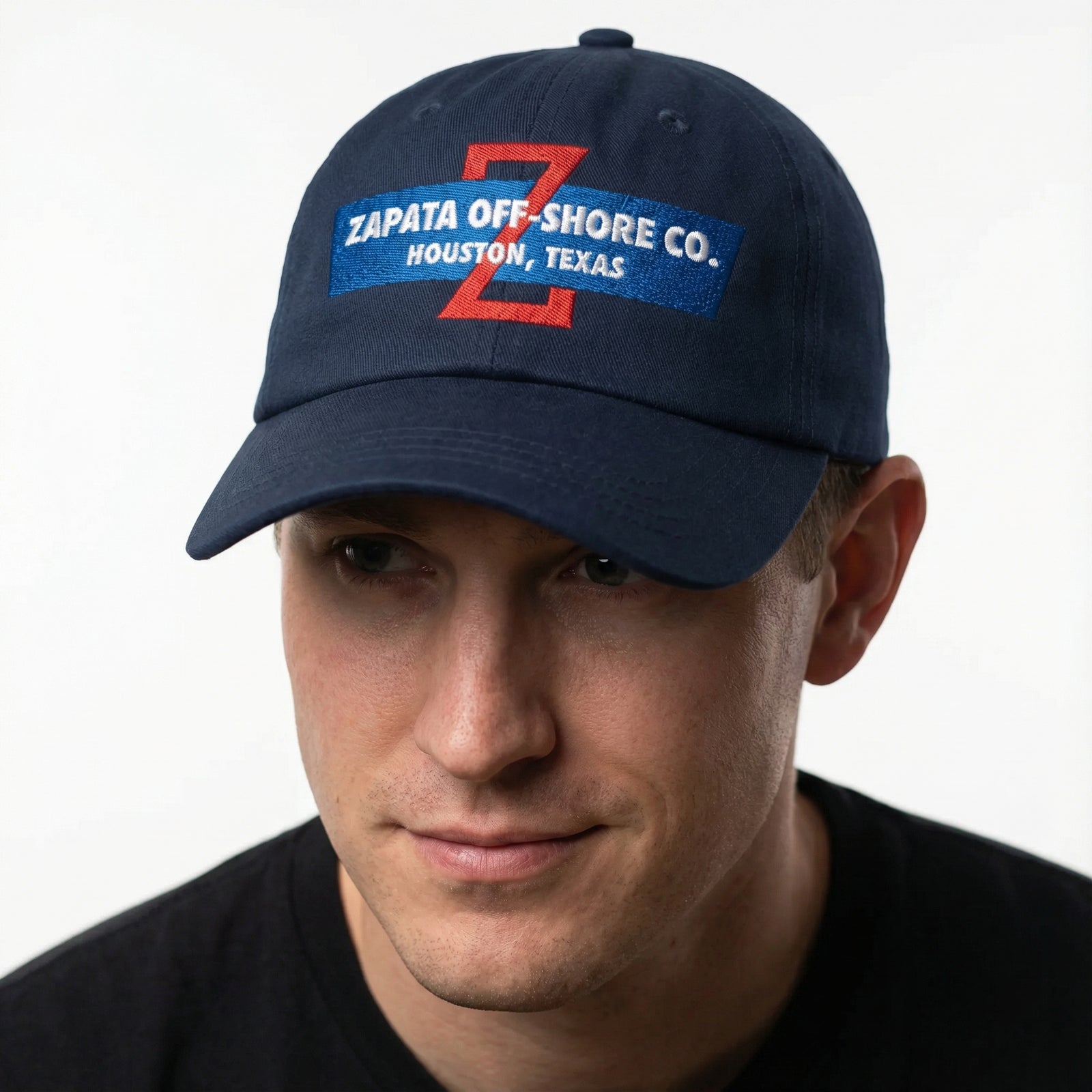 Man wearing a navy blue cap with Zapata Off-Shore Co. branding on a white background