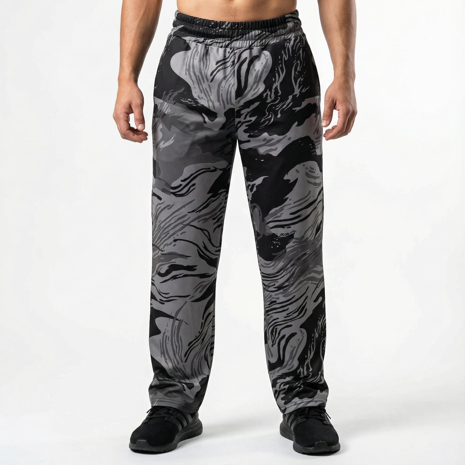 Person wearing black and gray camouflage pants on a white background