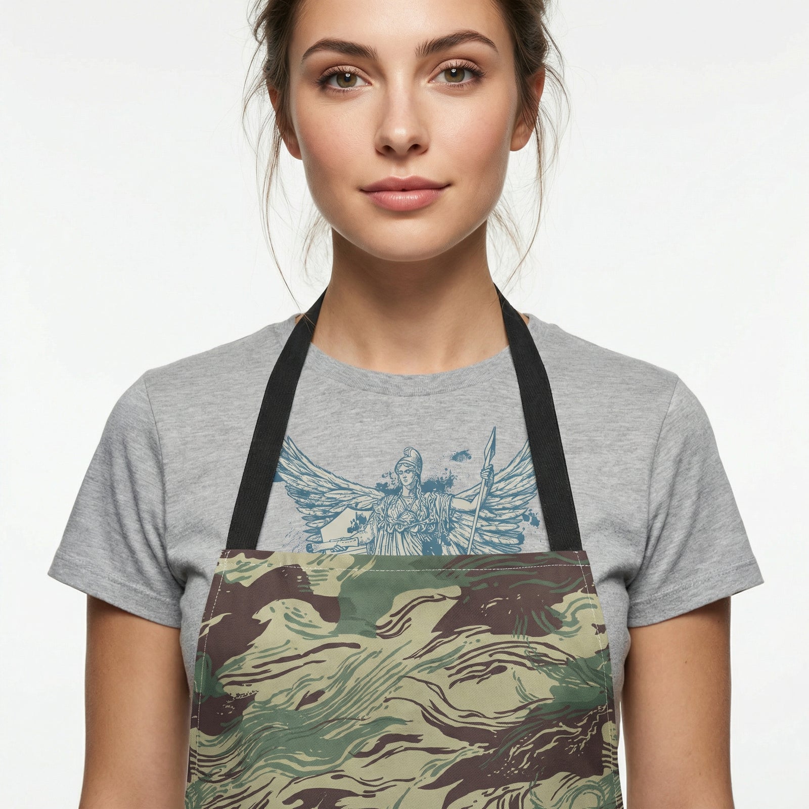 Woman wearing a gray t-shirt with a graphic design and a camouflage apron on a white background