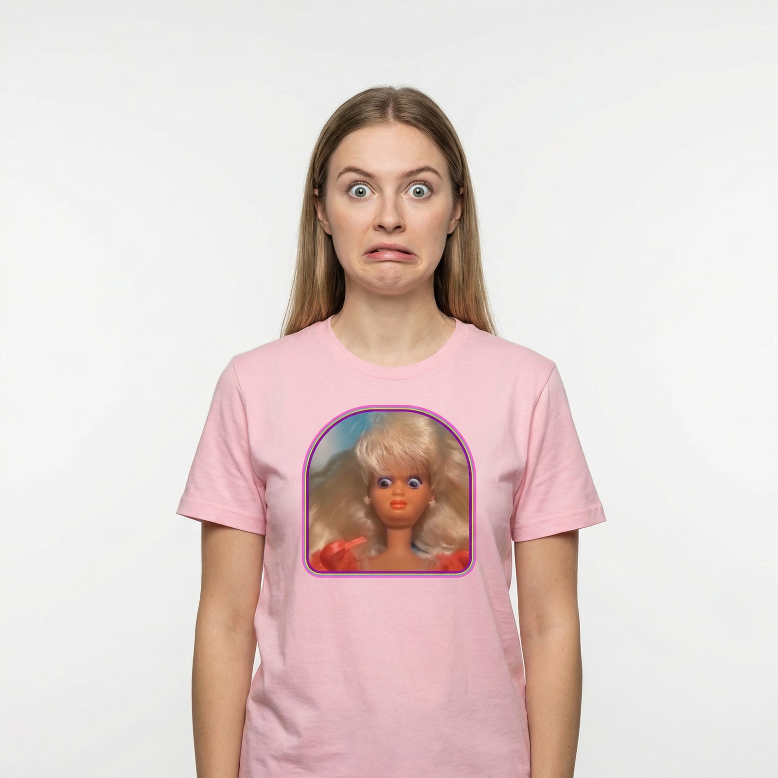 Person wearing a pink t-shirt with a graphic of a doll on a white background
