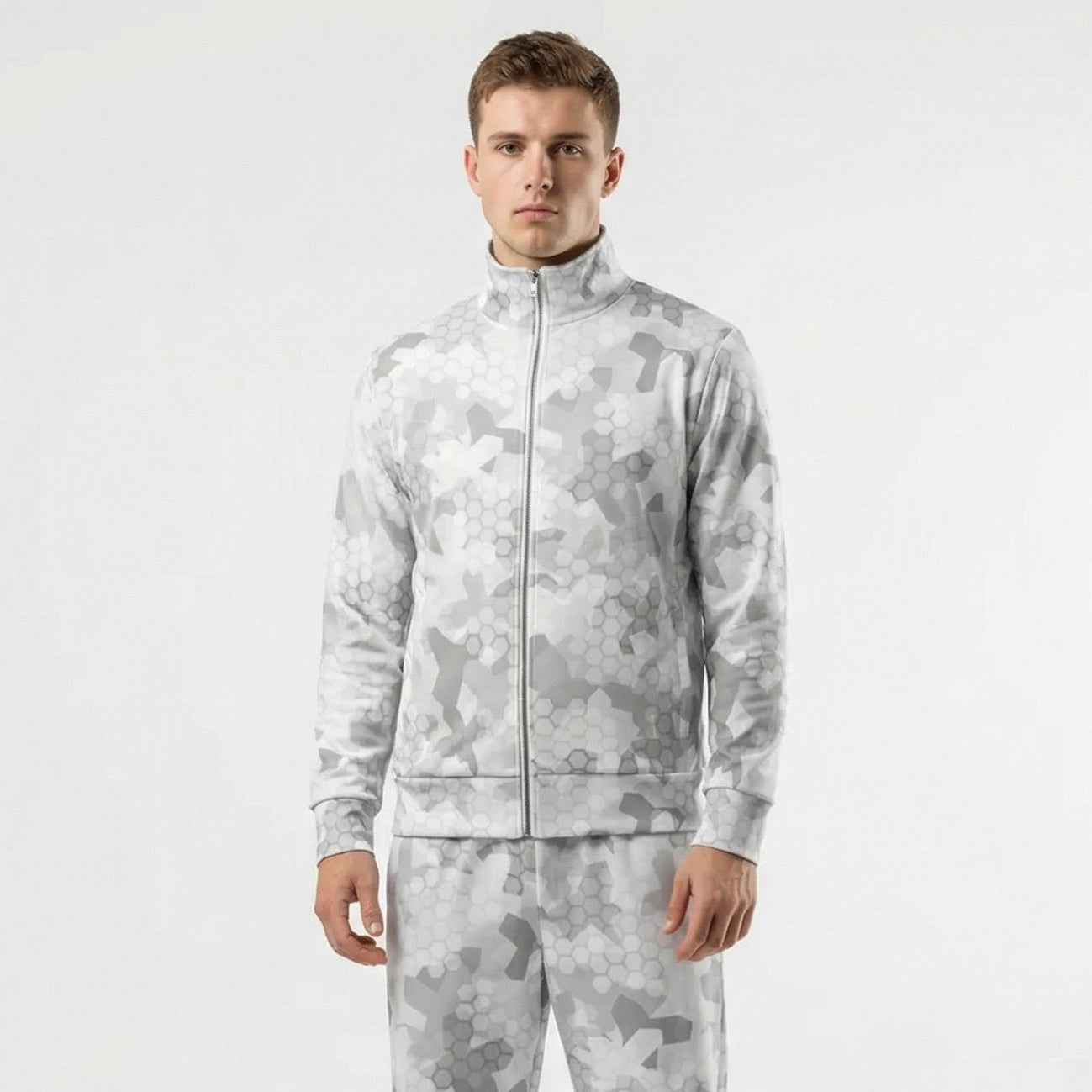 Man wearing a gray camouflage tracksuit on a white background
