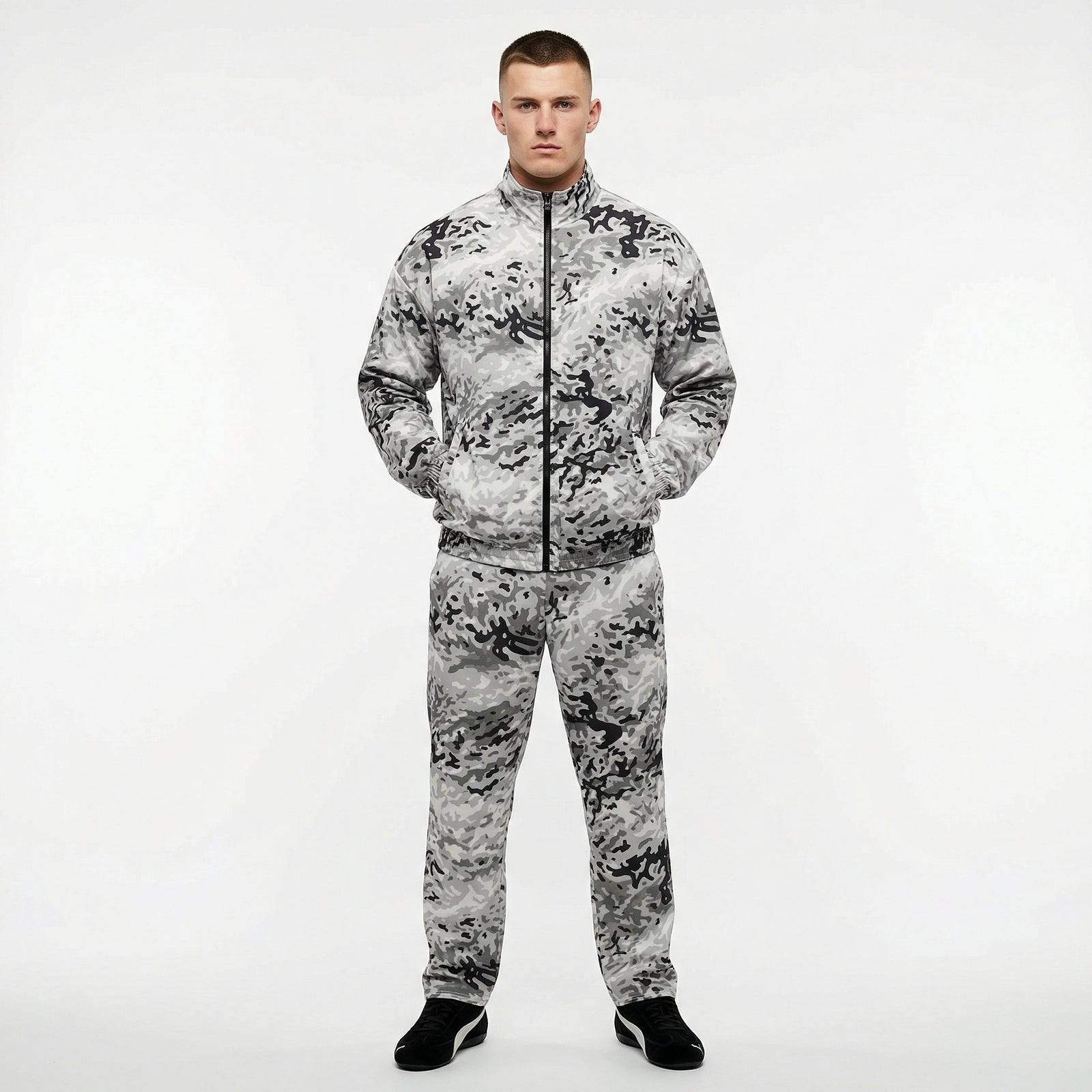 Man wearing a gray camouflage tracksuit on a white background