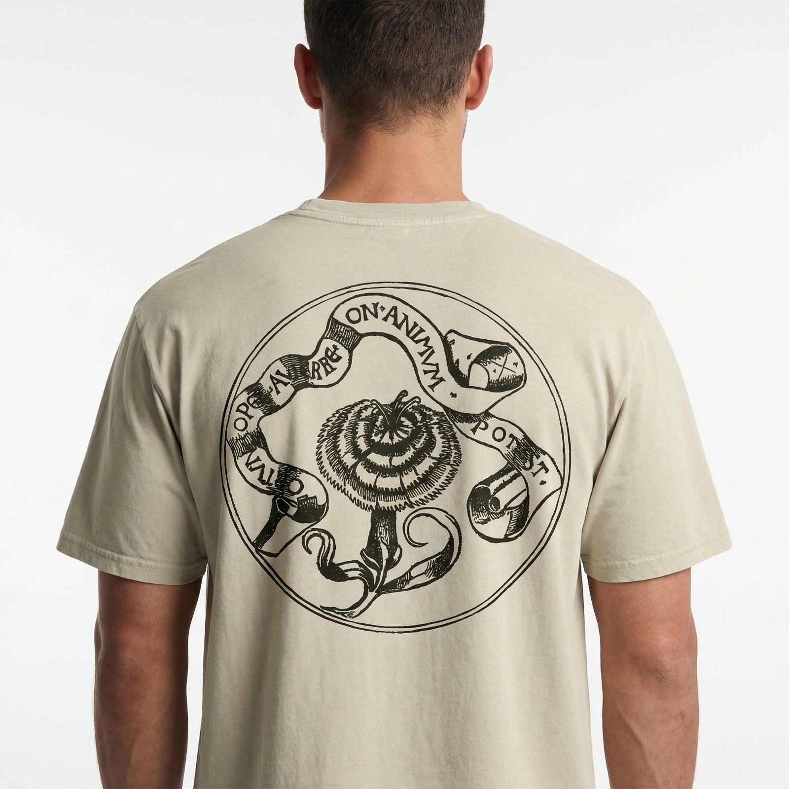 Man wearing a beige t-shirt with a black circular design on the back against a white background