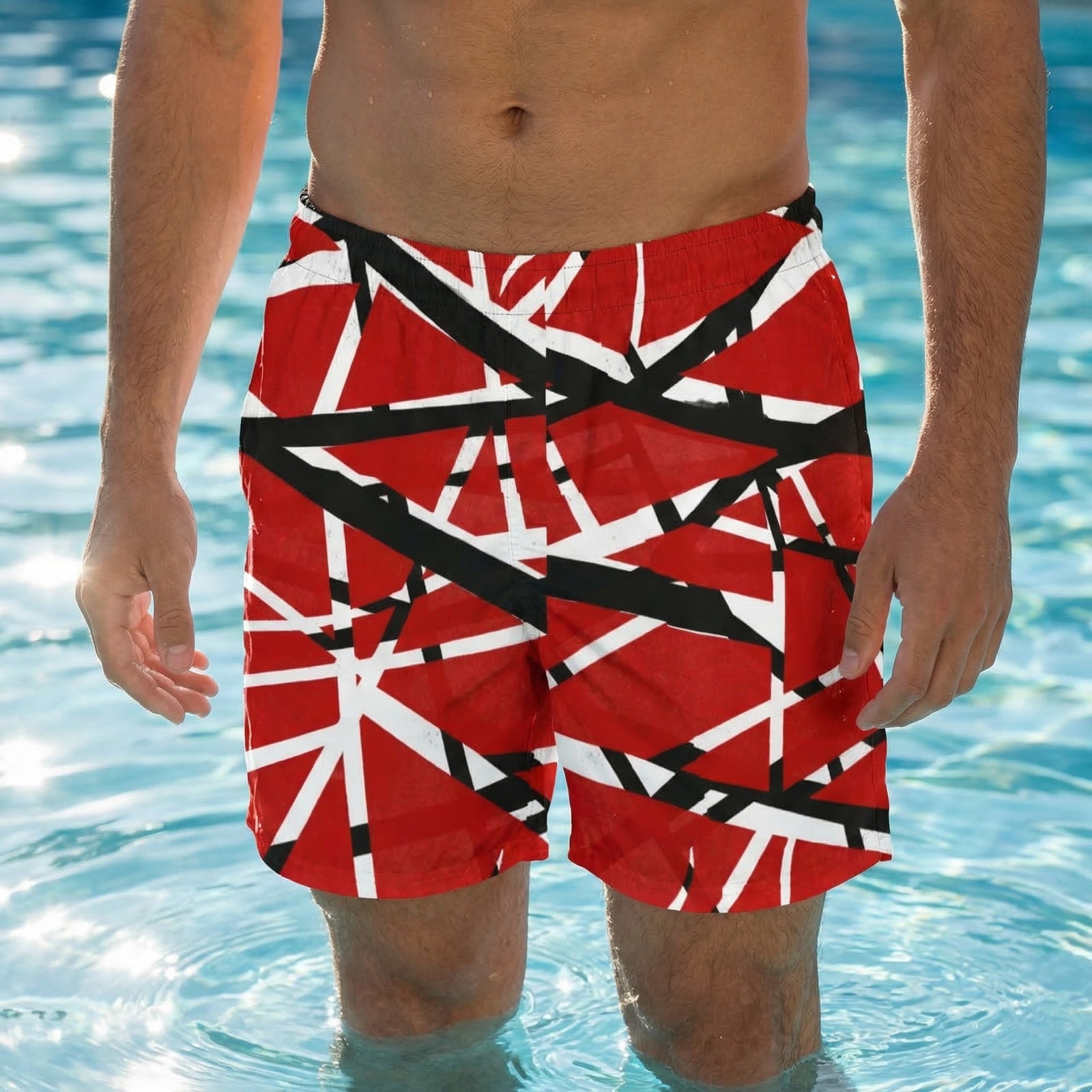 Person wearing red swim shorts with black and white cross patterns in a pool.