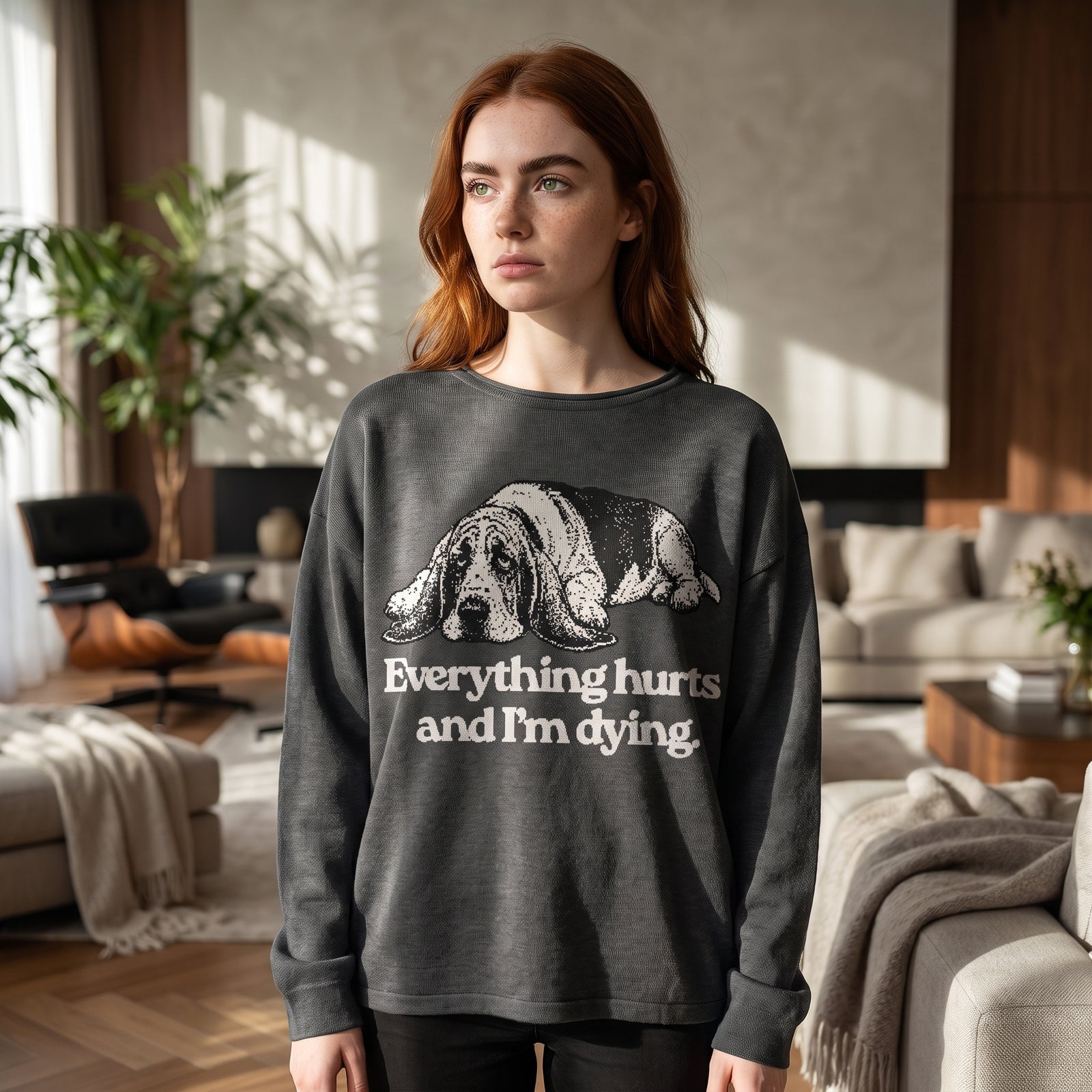 Woman wearing Everything Hurts and I'm Dying basset hound sweater in charcoal, relaxed fit, lifestyle photo
