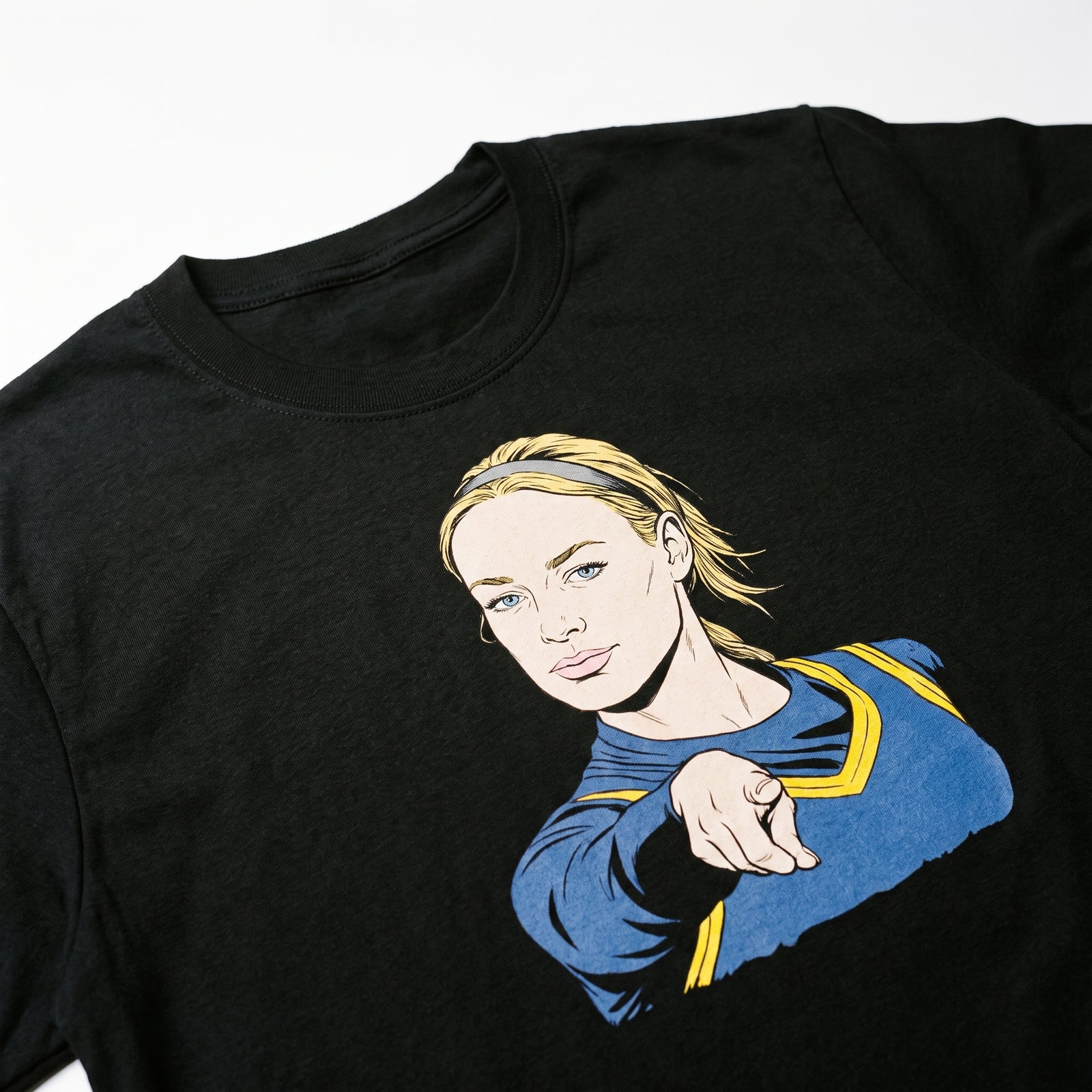 Black t-shirt with a graphic of a woman in a blue outfit on a white background