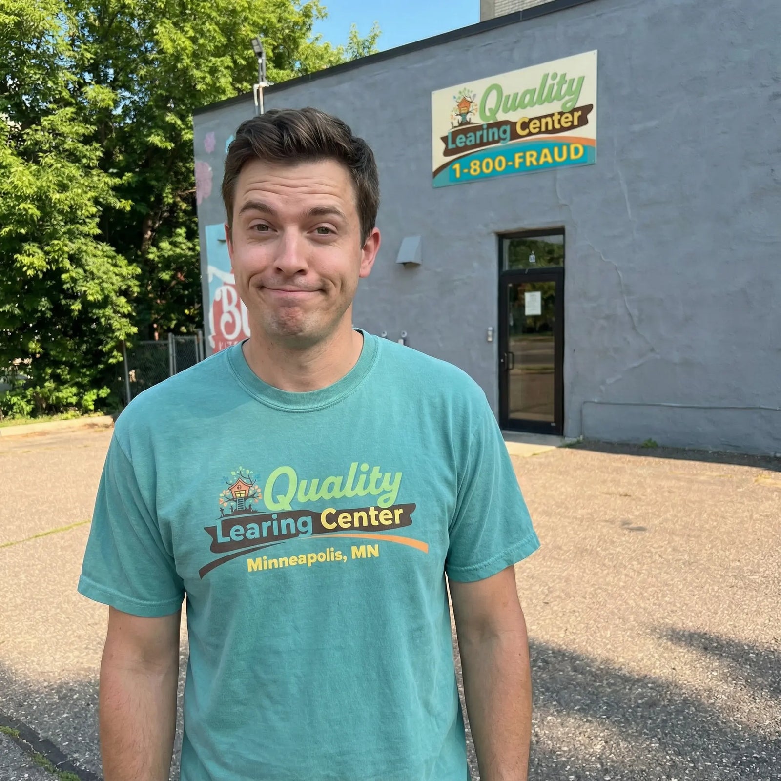 Man wearing a teal t-shirt with 'Quality Learning Center' logo standing in front of a building.