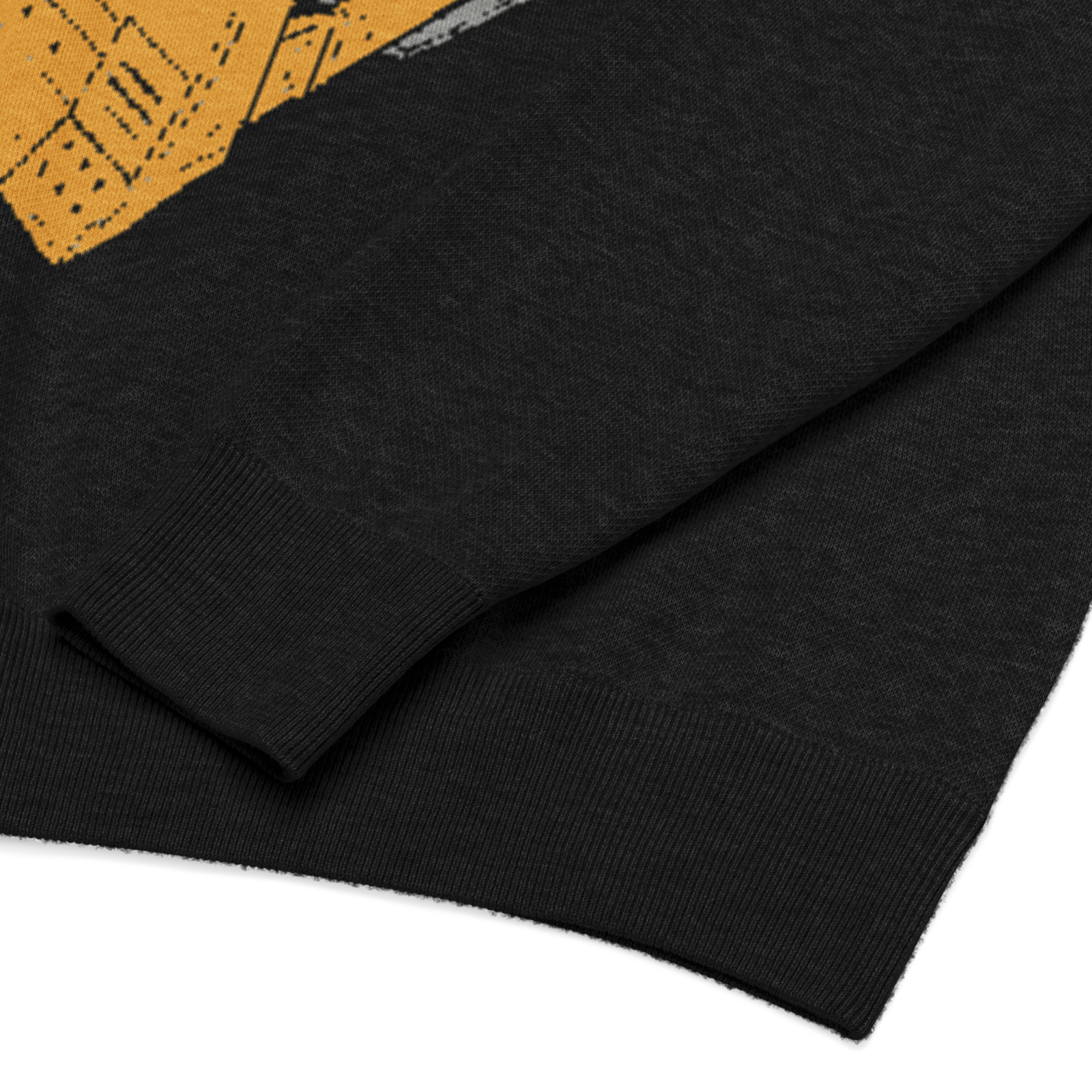 Close-up of a black sweater with a yellow pattern on a white background