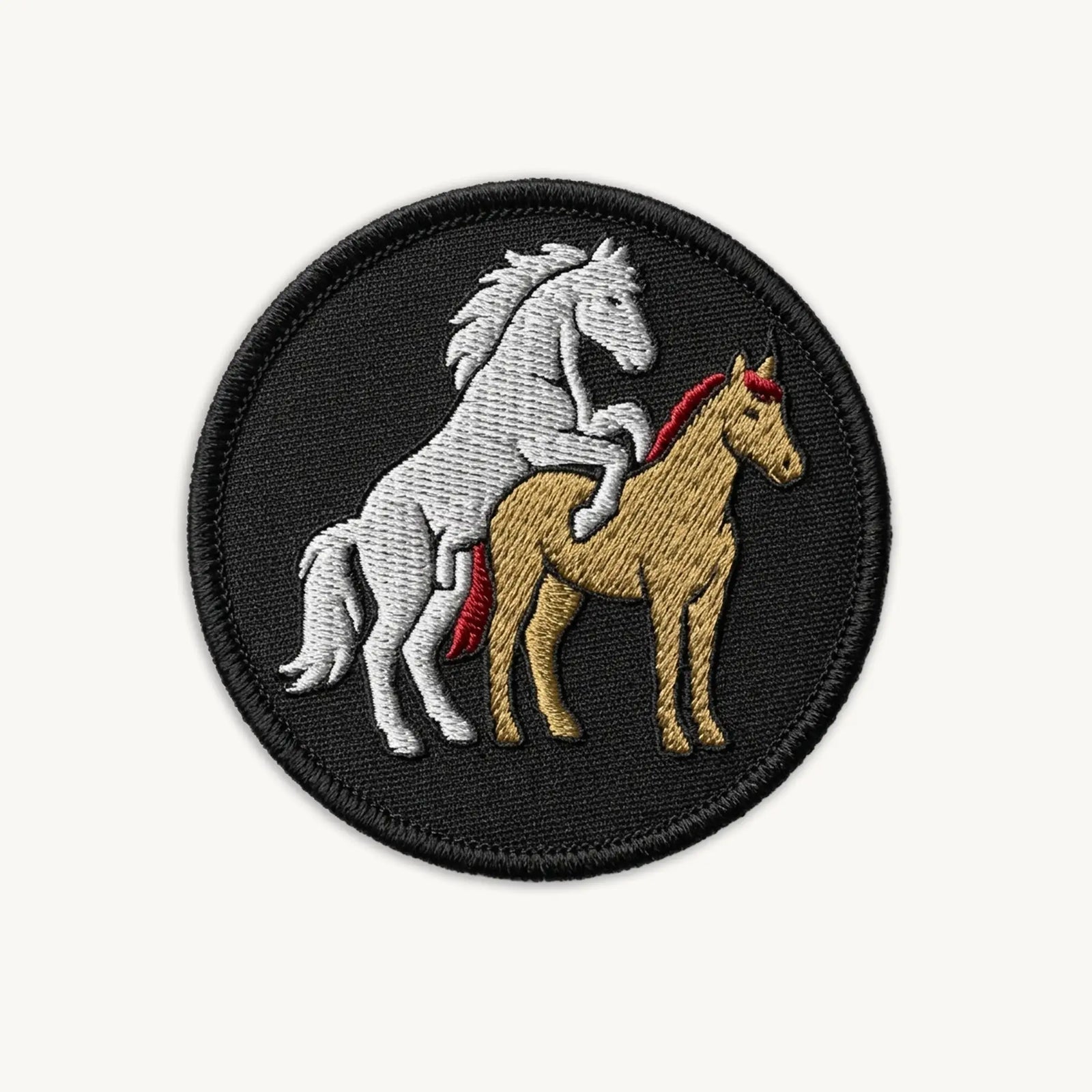 Embroidered patch with two horses on a black background