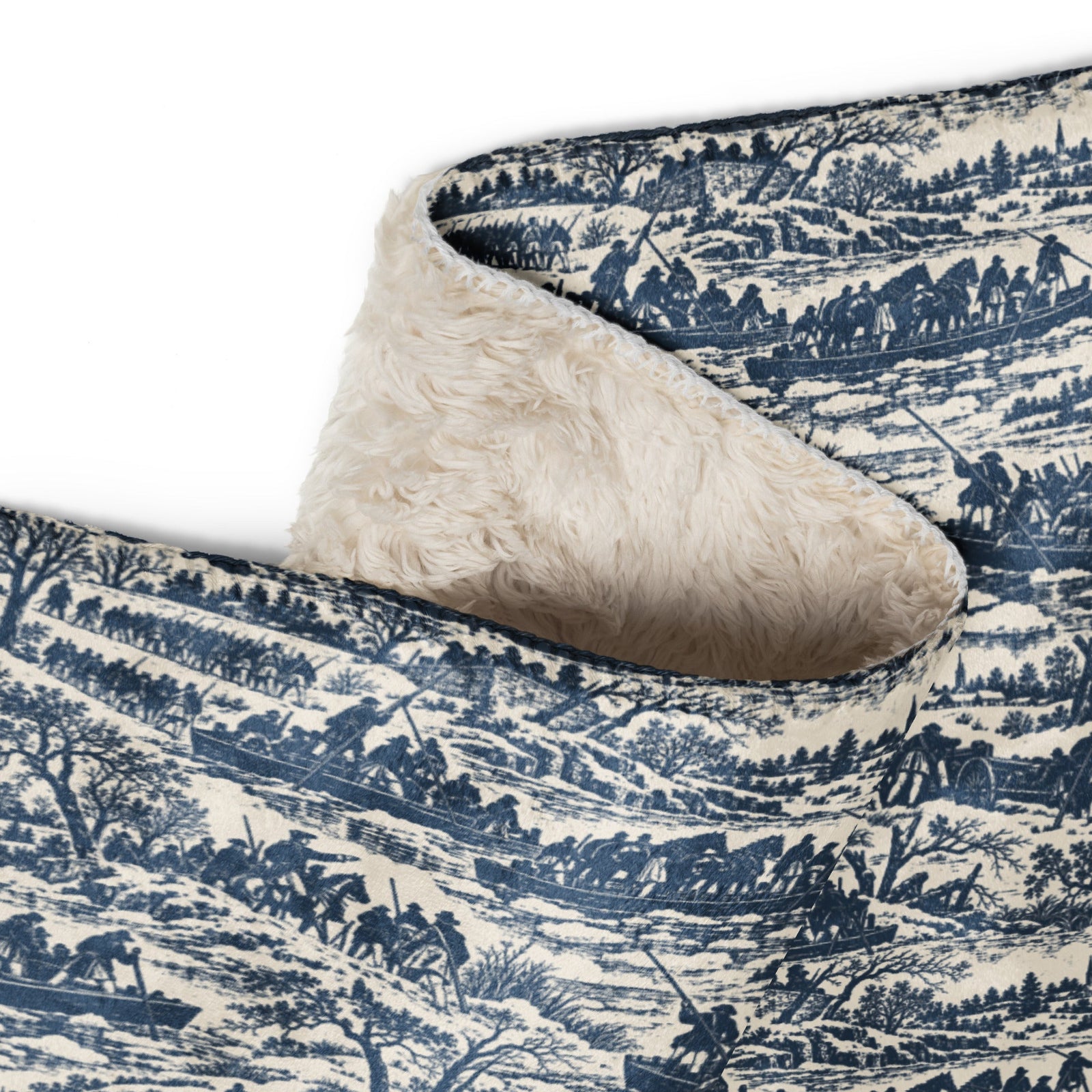 A close-up of a folded throw blanket showing a navy blue and cream landscape pattern on one side and a soft cream sherpa fleece backing on the other, set against a plain white background.