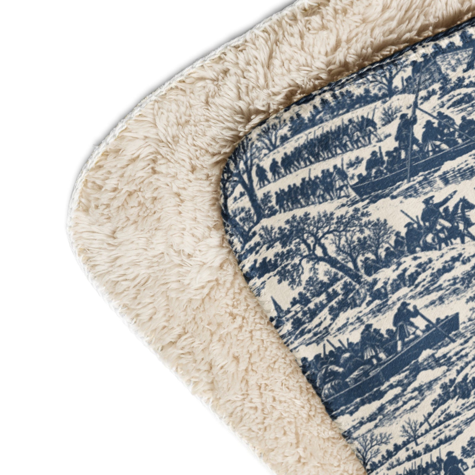 Close-up corner view of a rug showing a blue and cream forest patterned top side and a thick cream sherpa-like underside on a white background.