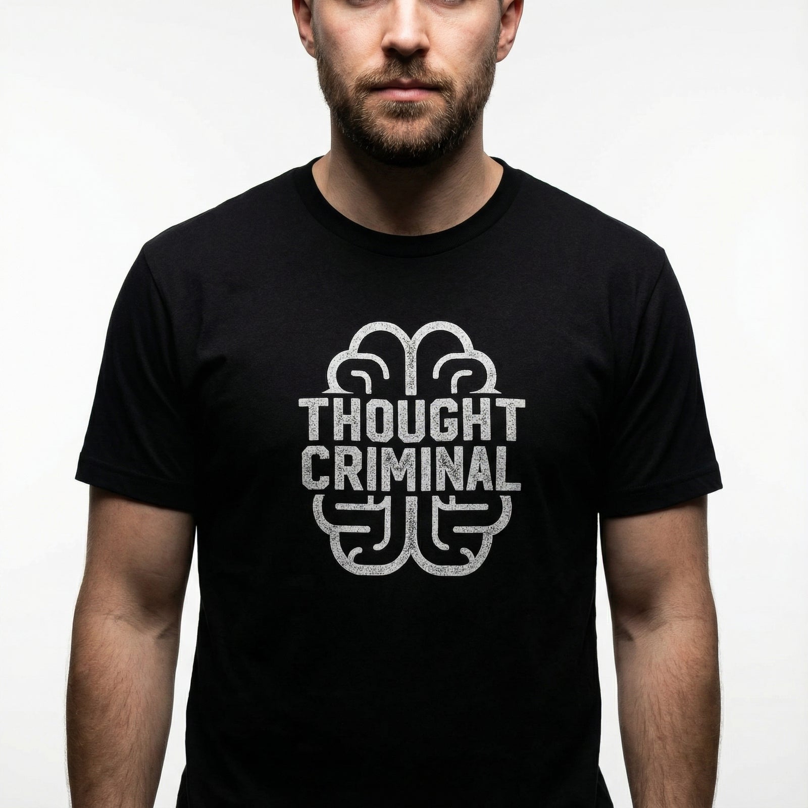 Man wearing a black t-shirt with 'Thought Criminal' graphic design on a plain background