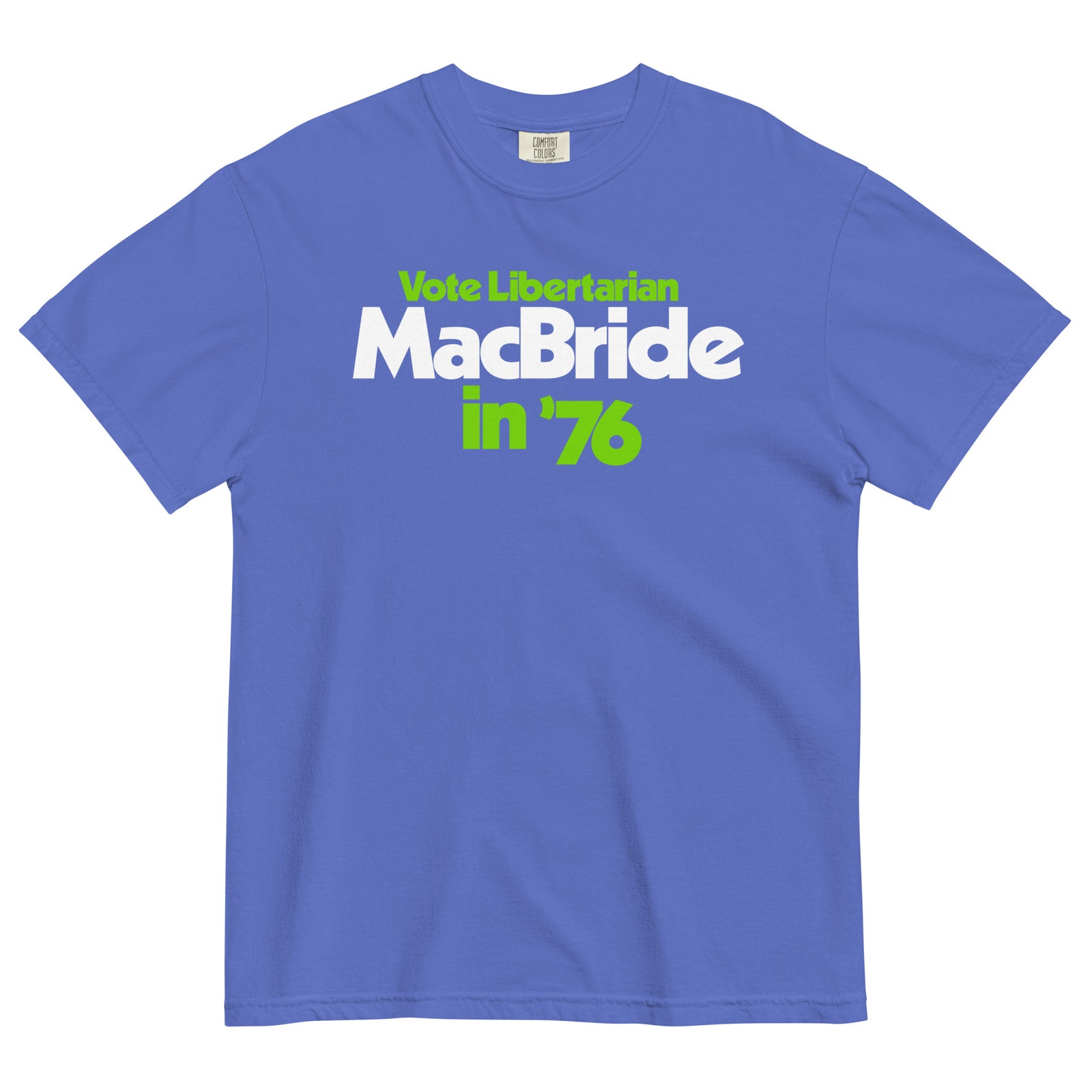 A royal blue short-sleeve t-shirt with a graphic print reading 'Vote Libertarian MacBride in '76' in white and lime green text, displayed flat against a white background.