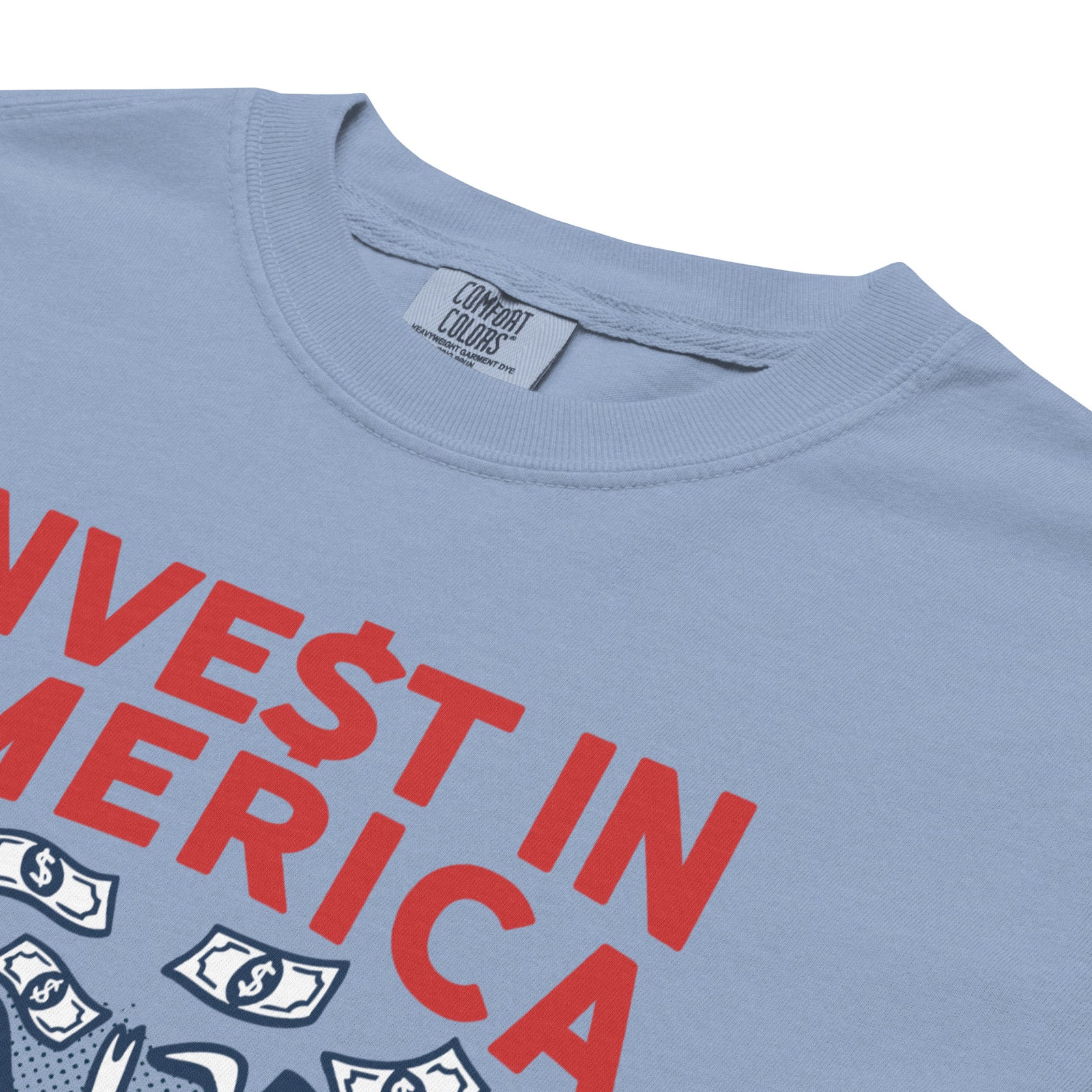 Blue t-shirt with red text 'VEST IN AMERICA' and dollar signs on a white background
