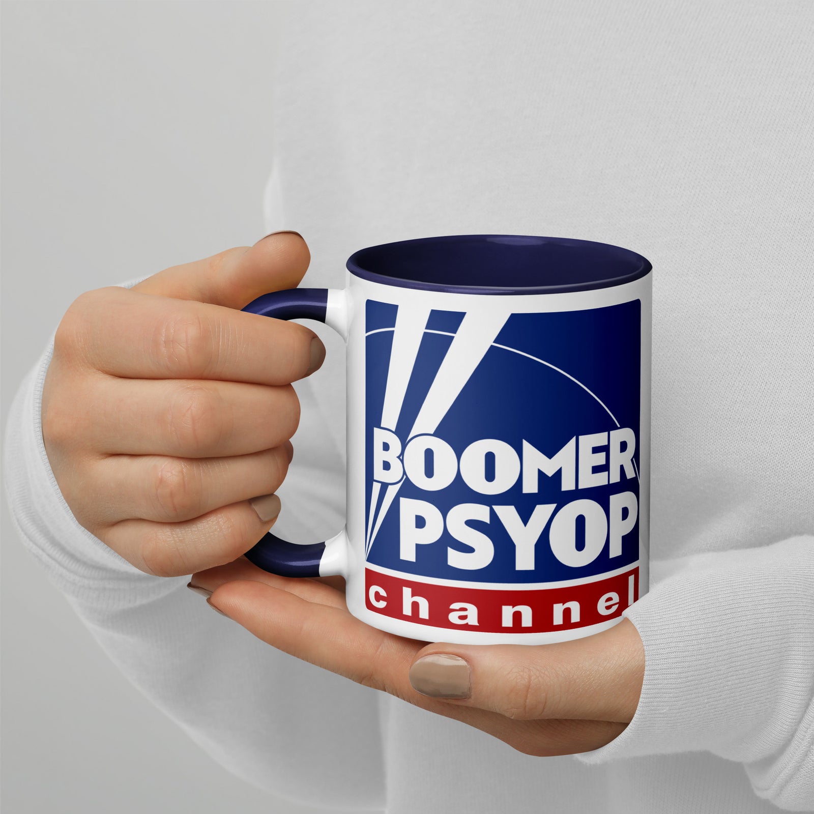 Mug with 'Boomer Psyop Channel' design held by a person against a light gray background