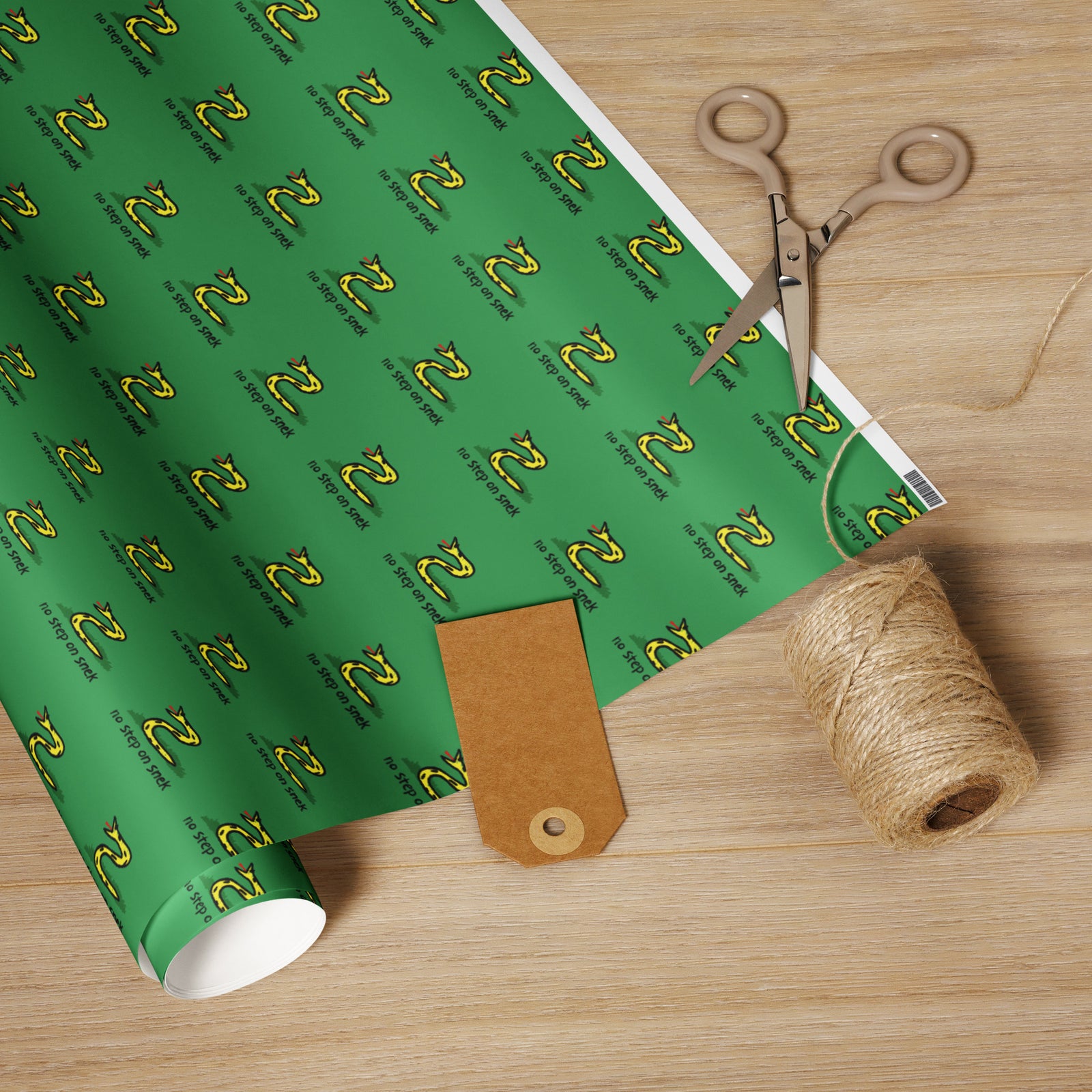 Green wrapping paper with a pattern, scissors, and twine on a wooden surface