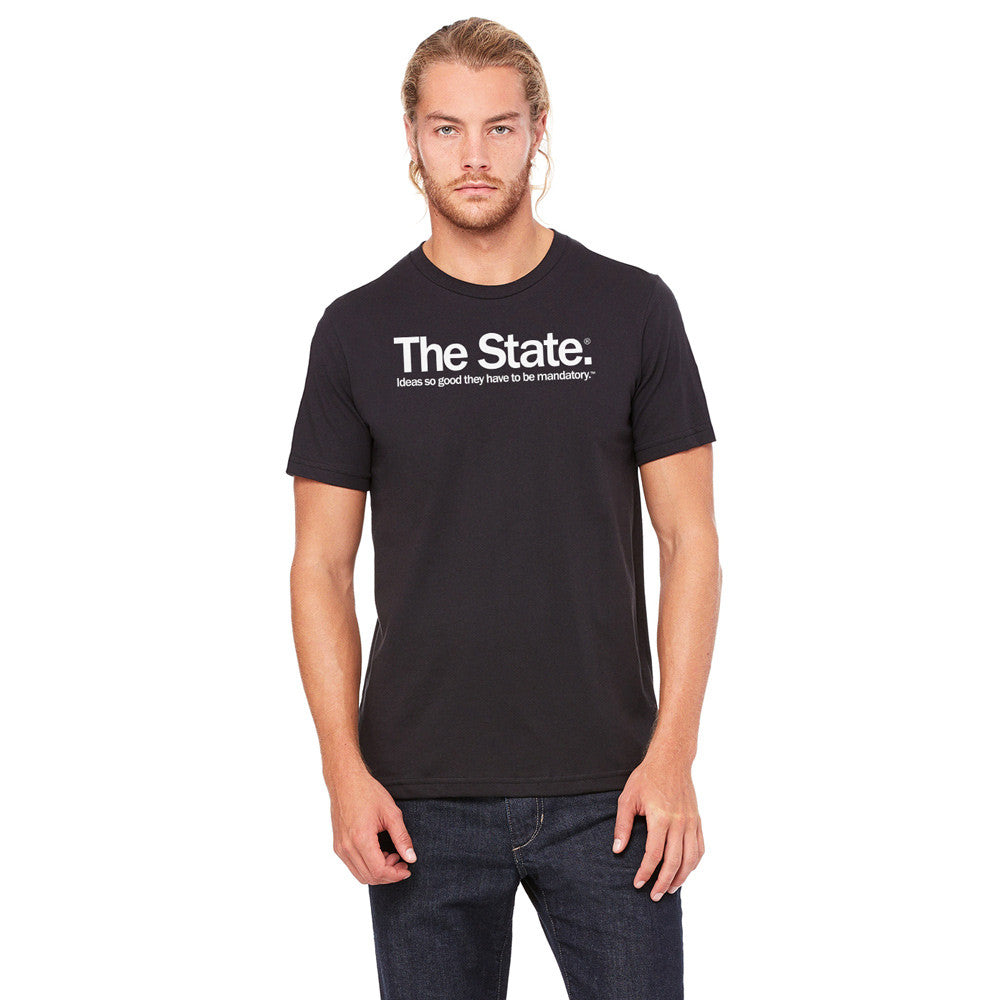 Man wearing a black t-shirt from Liberty Maniacs that says "THE STATE. IDEAS SO GOOD THEY HAVE TO BE MANDATORY" written in white text.
