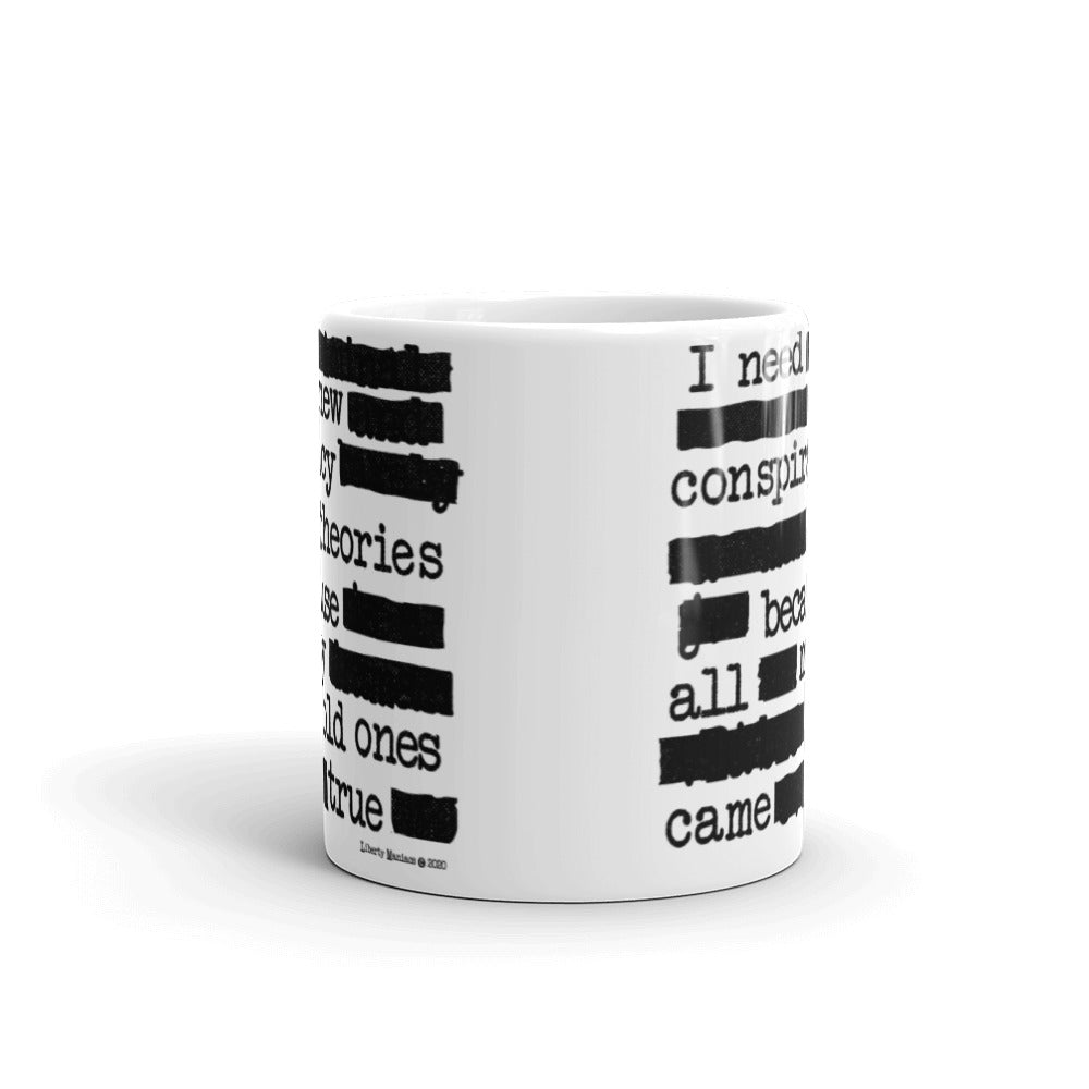 White ceramic mug with text pattern depicting a humorous conspiracy theory statement "I need new conspiracy theories because all my old ones came true."
