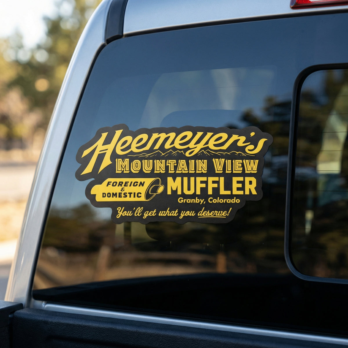 Decal on a car window advertising 'Heemeyer's Mountain View Muffler' in Granby, Colorado.