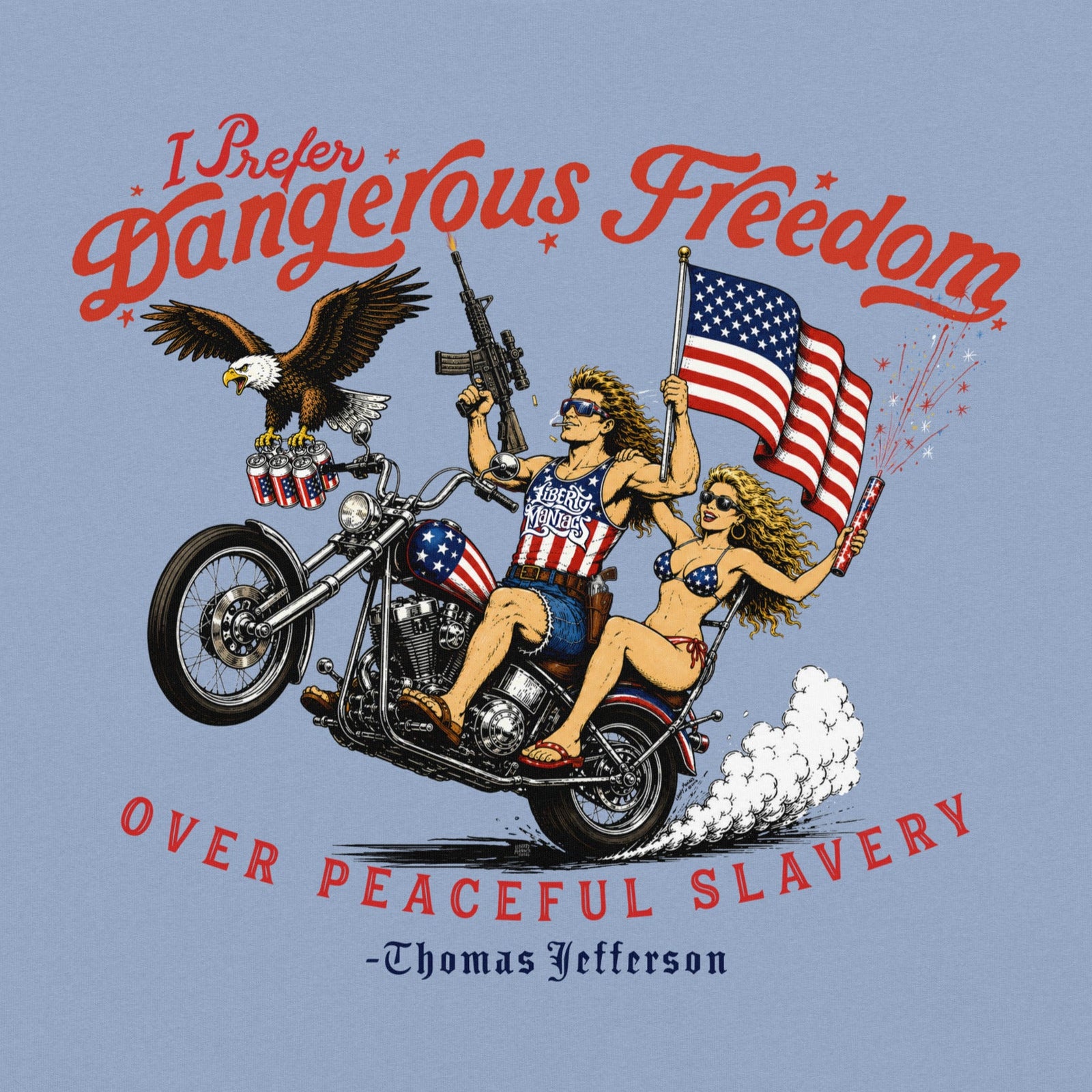 A light blue crewneck t-shirt featuring a retro-style illustration of a man and women on a motorcycle with American flags, an eagle, and fireworks. Red text above reads 'I Prefer Dangerous Freedom' and text below reads 'OVER PEACEFUL SLAVERY -Thomas Jefferson'. By Liberty Maniacs