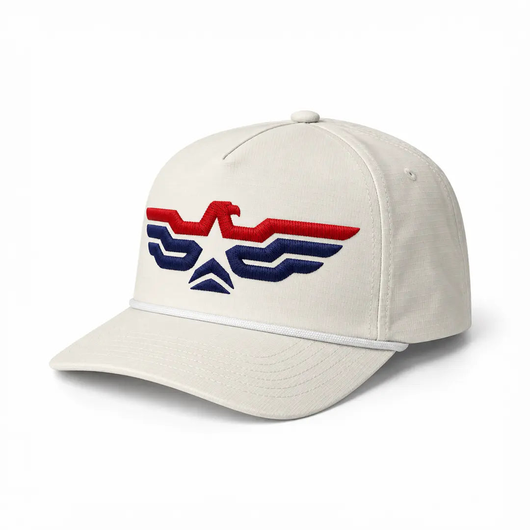 Ivory eagle rope cap by Liberty Maniacs, three-quarter front view showing red and navy satin puff embroidery and curved bill