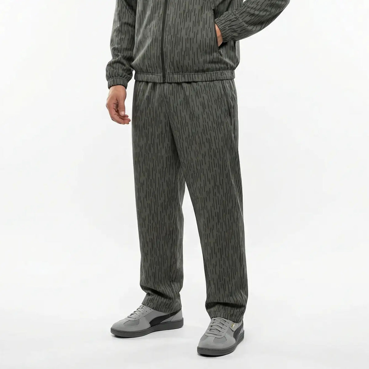 Person wearing a gray striped sweater and matching pants on a white background