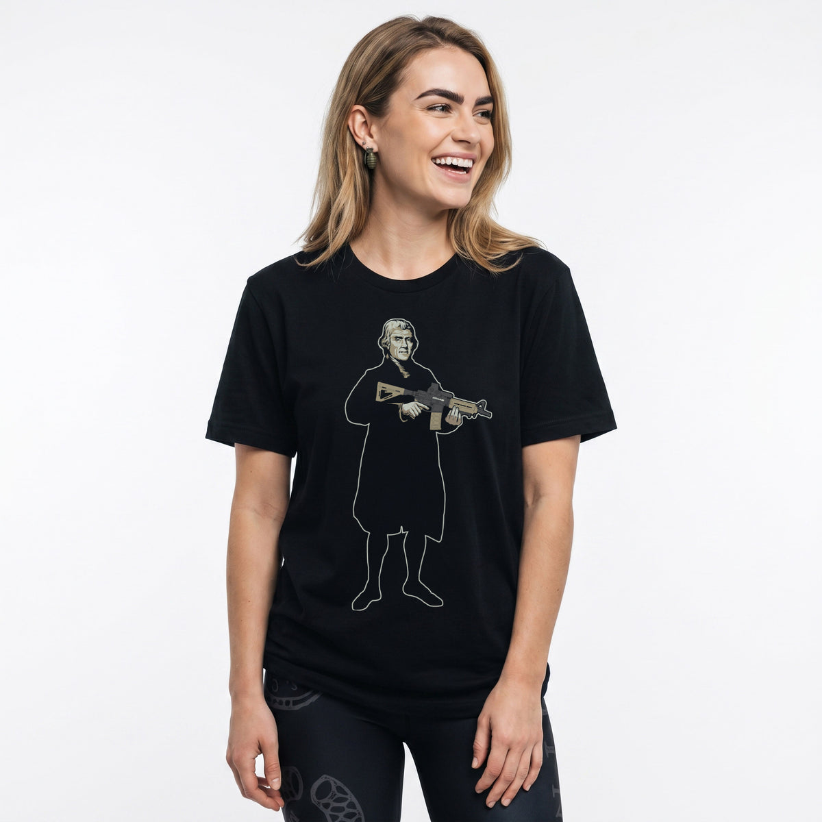 A woman wearing a Thomas Jefferson With a Carbine T-Shirt by Liberty Maniacs and Join or Die black patriotic leggings. 