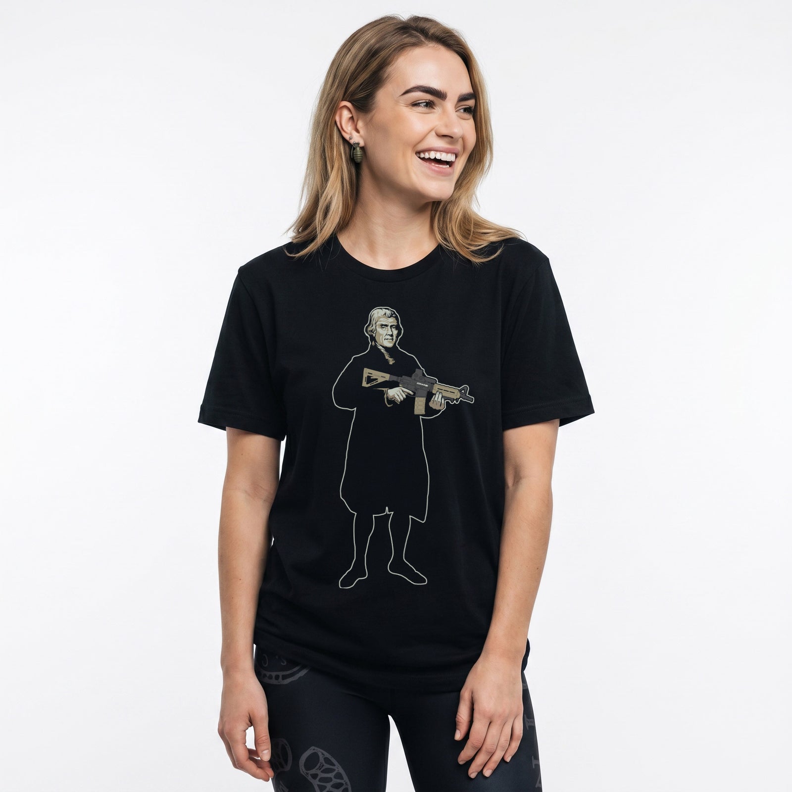 A woman wearing a Thomas Jefferson With a Carbine T-Shirt by Liberty Maniacs and Join or Die black patriotic leggings. 