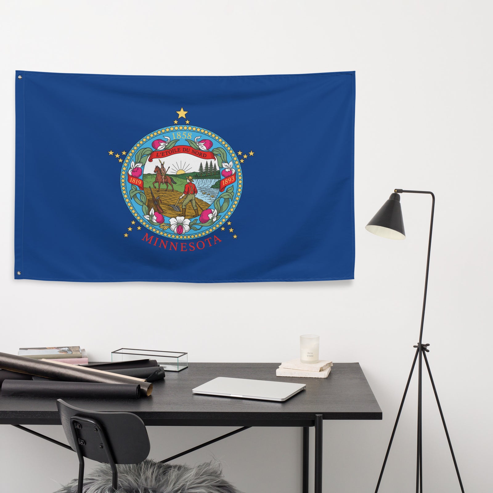 Minnesota state flag hanging on a white wall above a desk.