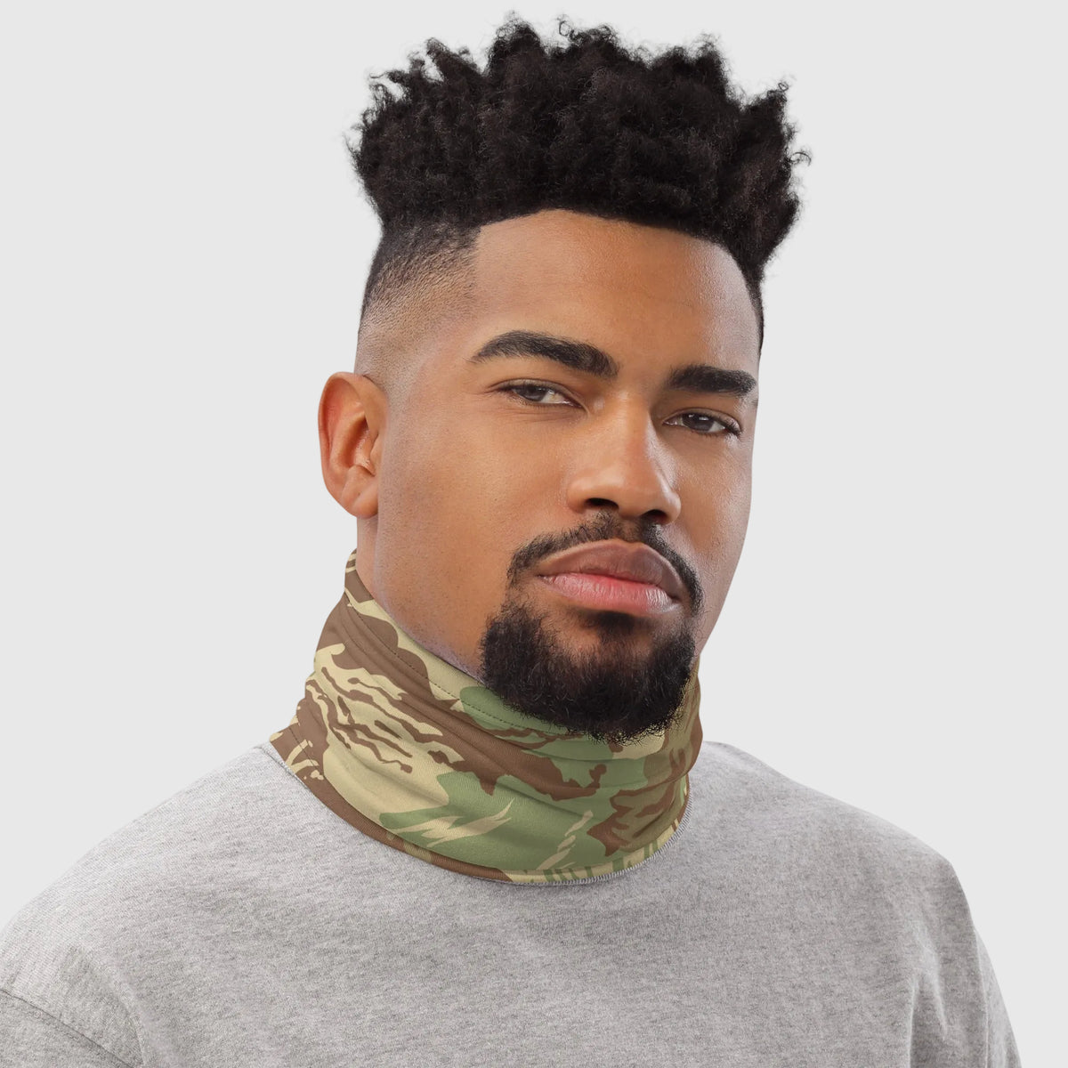Man wearing a camouflage neck gaiter against a white background