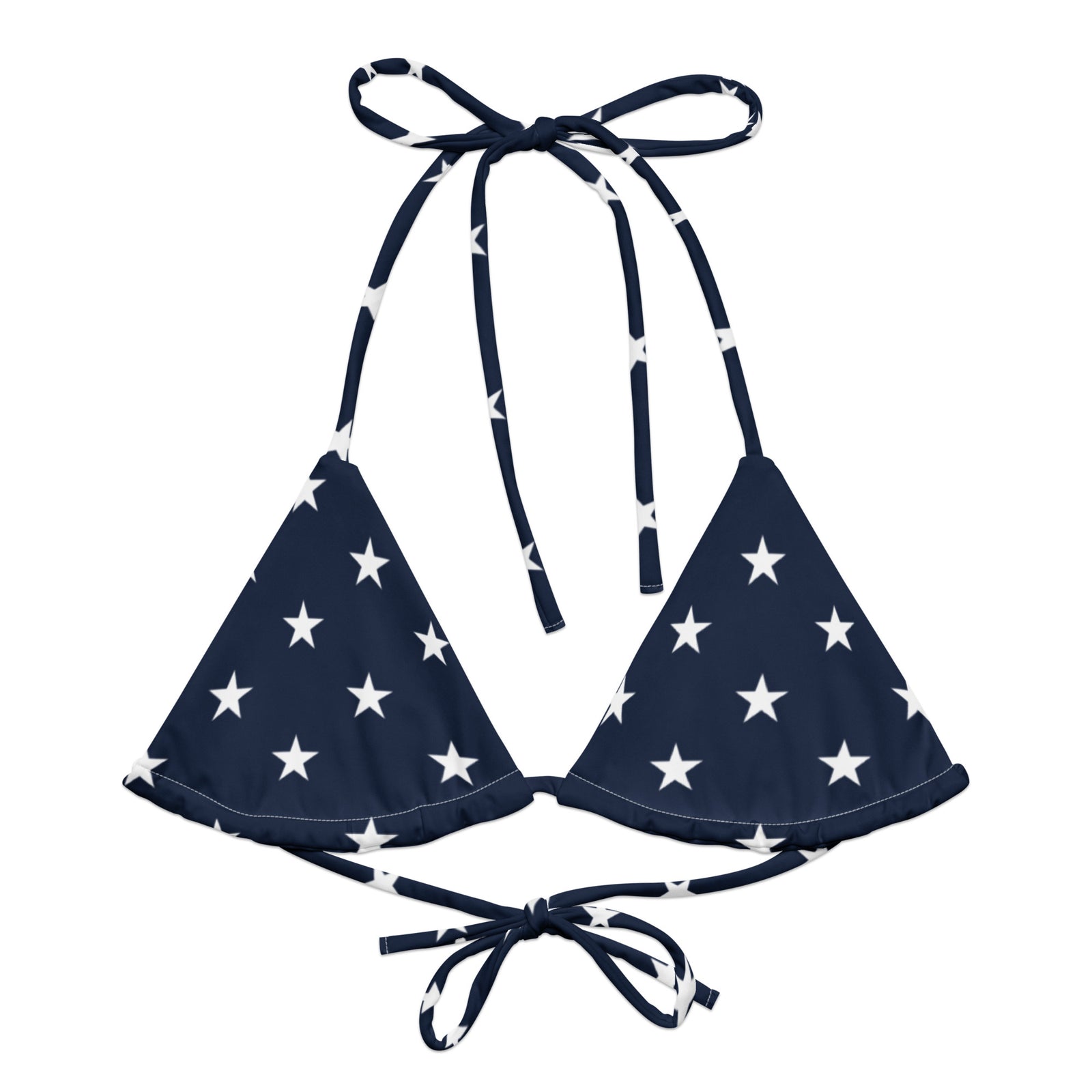 Woman wearing a navy blue bikini top with white star pattern on a gray background