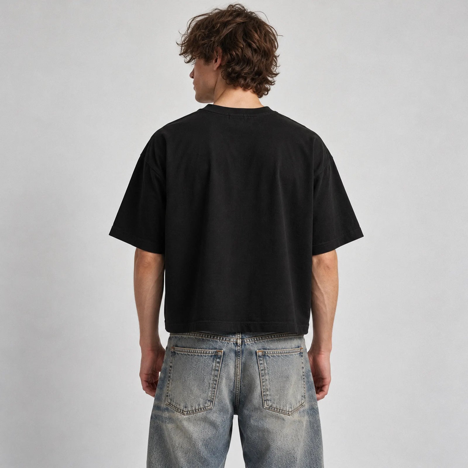 Black Military Industrial Complex boxy T-shirt on male model with relaxed dropped-shoulder fit