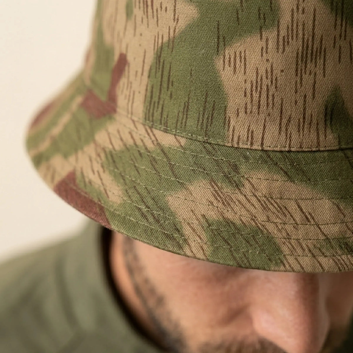 Close-up of a person wearing a camouflage bucket hat.