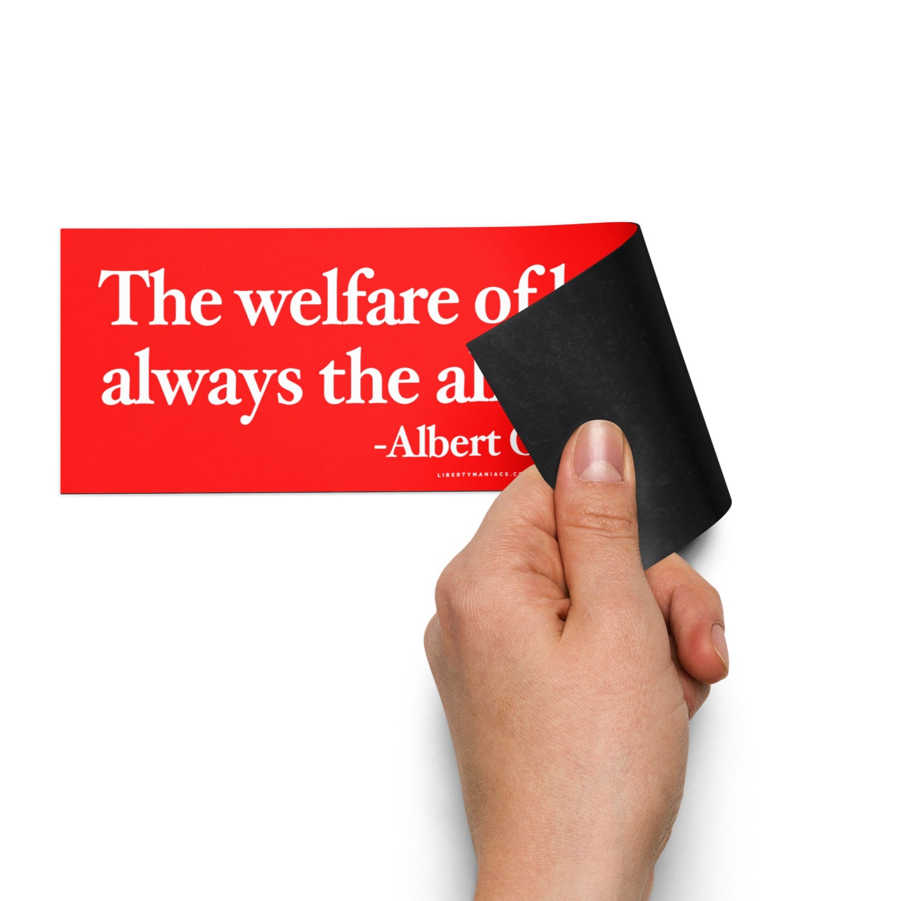 Hand holding a magnetic bumper sticker, featuring a quote by Albert Camus that states, "The welfare of humanity is always the alibi of tyrants."