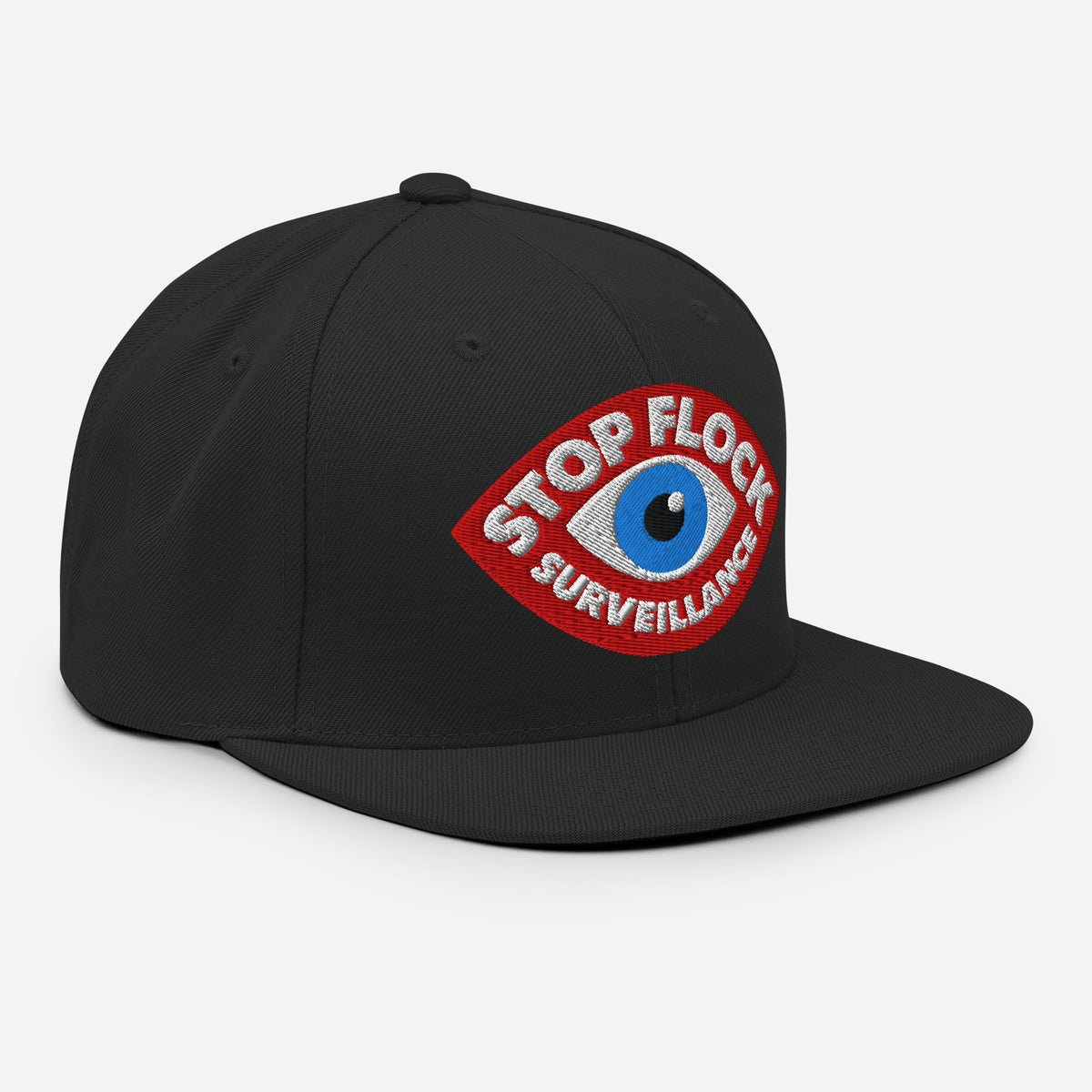 A black flat-brim baseball cap featuring a red embroidered patch with a blue eye and the words 'STOP FLOCK SURVEILLANCE' on a light gray background.