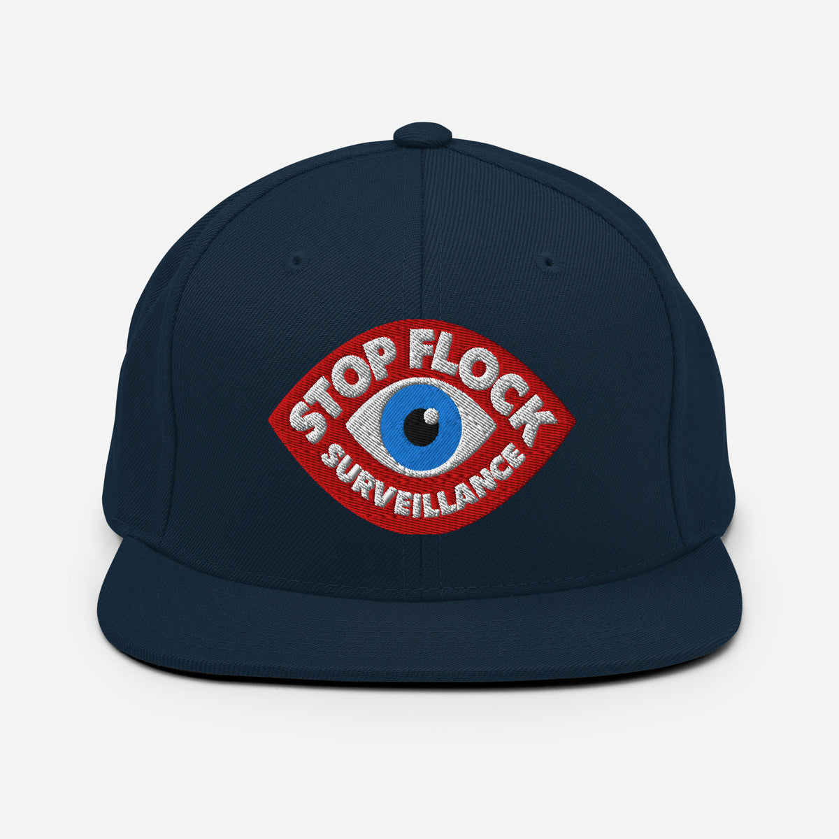 A dark navy blue flat-brim cap featuring a red, white, and blue embroidered patch on the front with the text 'STOP FLOCK SURVEILLANCE'.