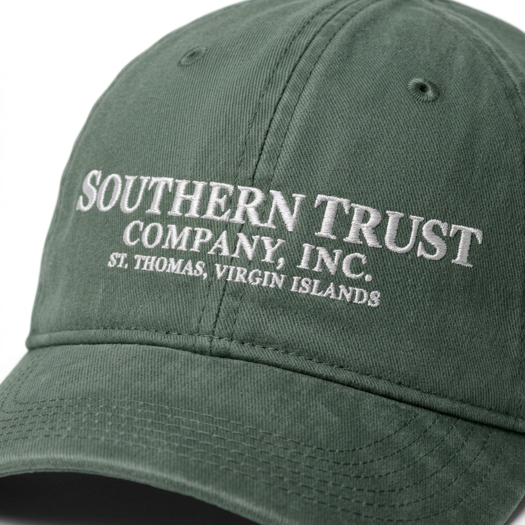 Close-up of the Southern Trust Company Moss green cap, showing embroidered company lettering and St. Thomas, Virgin Islands location
