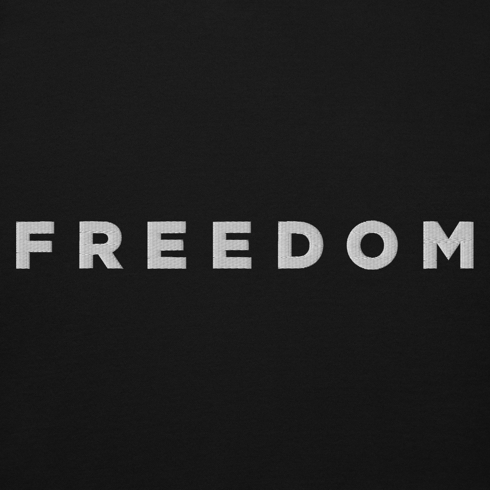Man wearing a black hoodie with 'FREEDOM' text on a light gray background